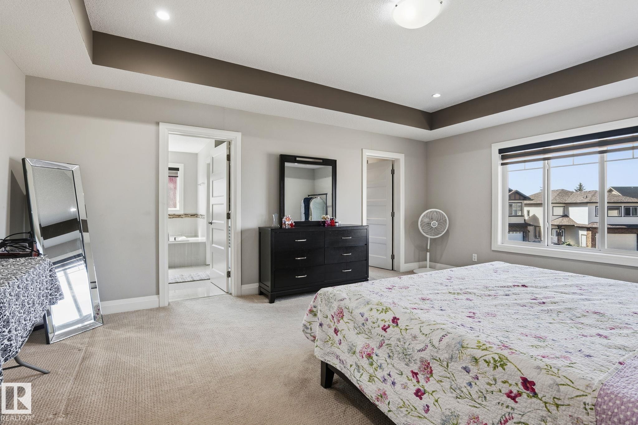 Spacious room featuring carpet flooring and a tray ceiling with recessed lighting - 731 57 Street Sw, Edmonton, AB - Indoor Photo Showing Bedroom
