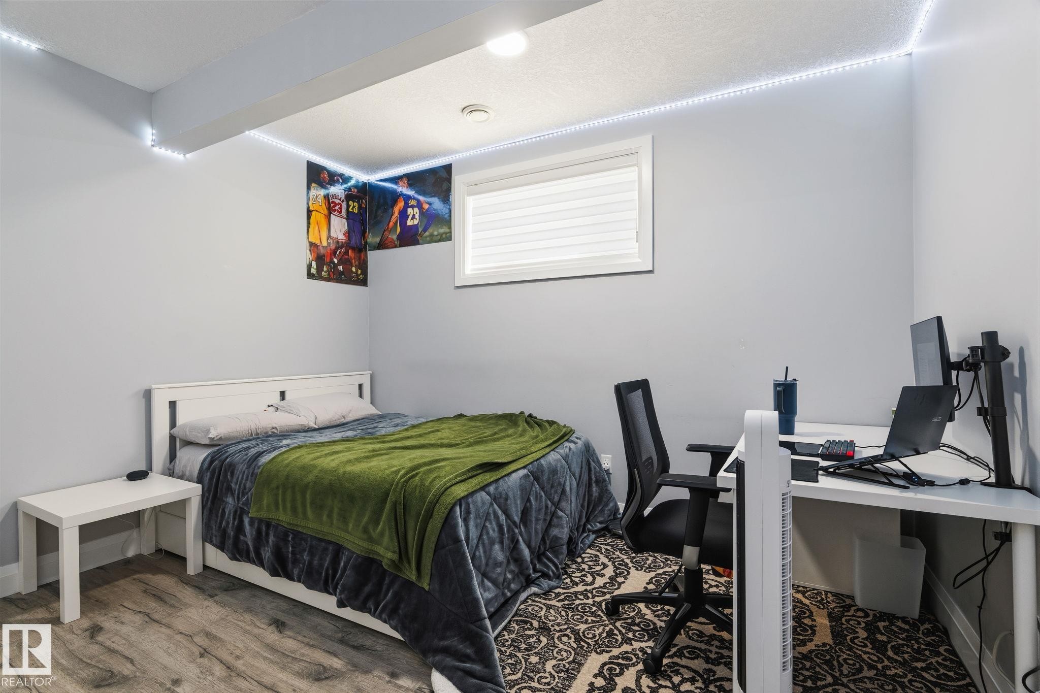 Spacious room featuring wood-finish flooring, a contemporary window with blinds, recessed ceiling lighting, and light gray wall paint - 731 57 Street Sw, Edmonton, AB - Indoor Photo Showing Bedroom
