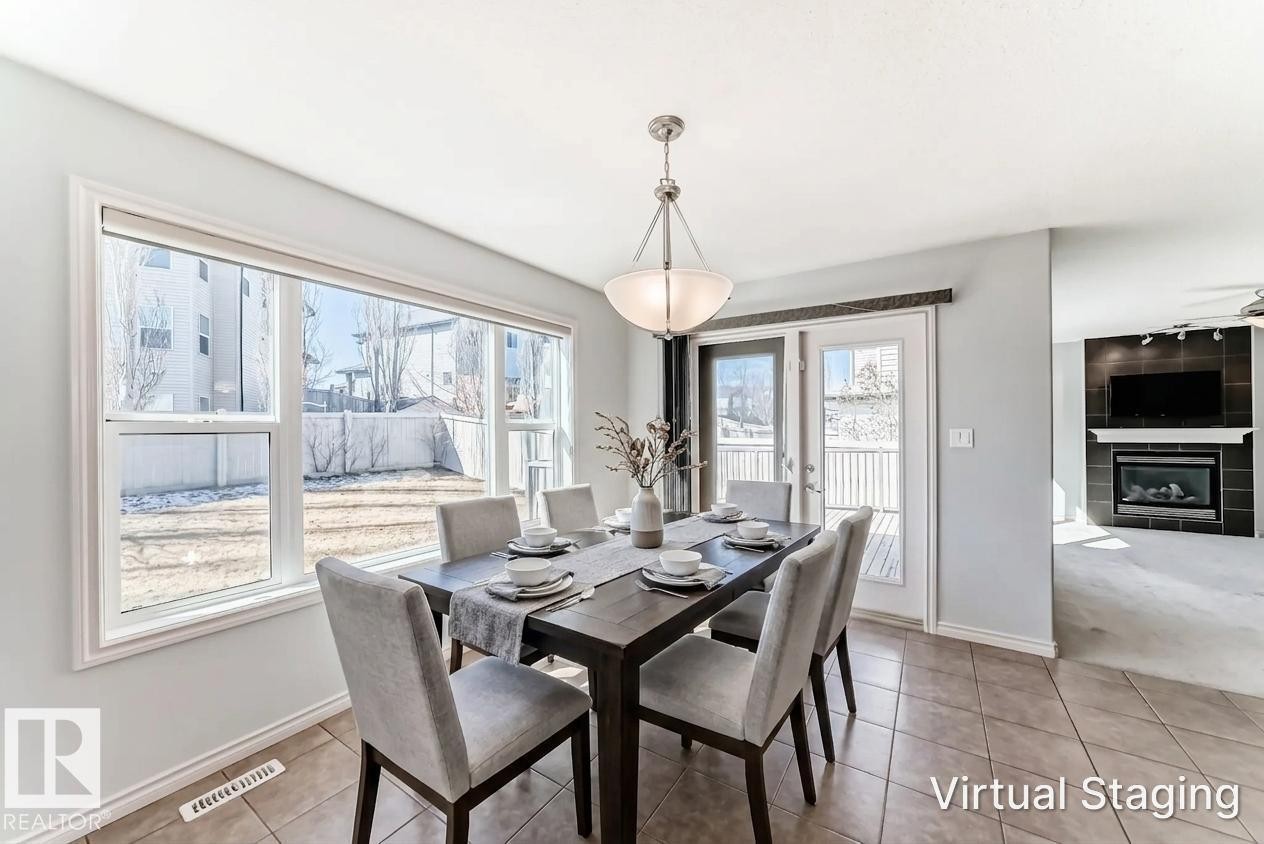 Dining area featuring tile flooring, a multi-pane window, and a door to an exterior deck - 6723 19 Avenue, Edmonton, AB - Indoor Photo Showing Dining Room