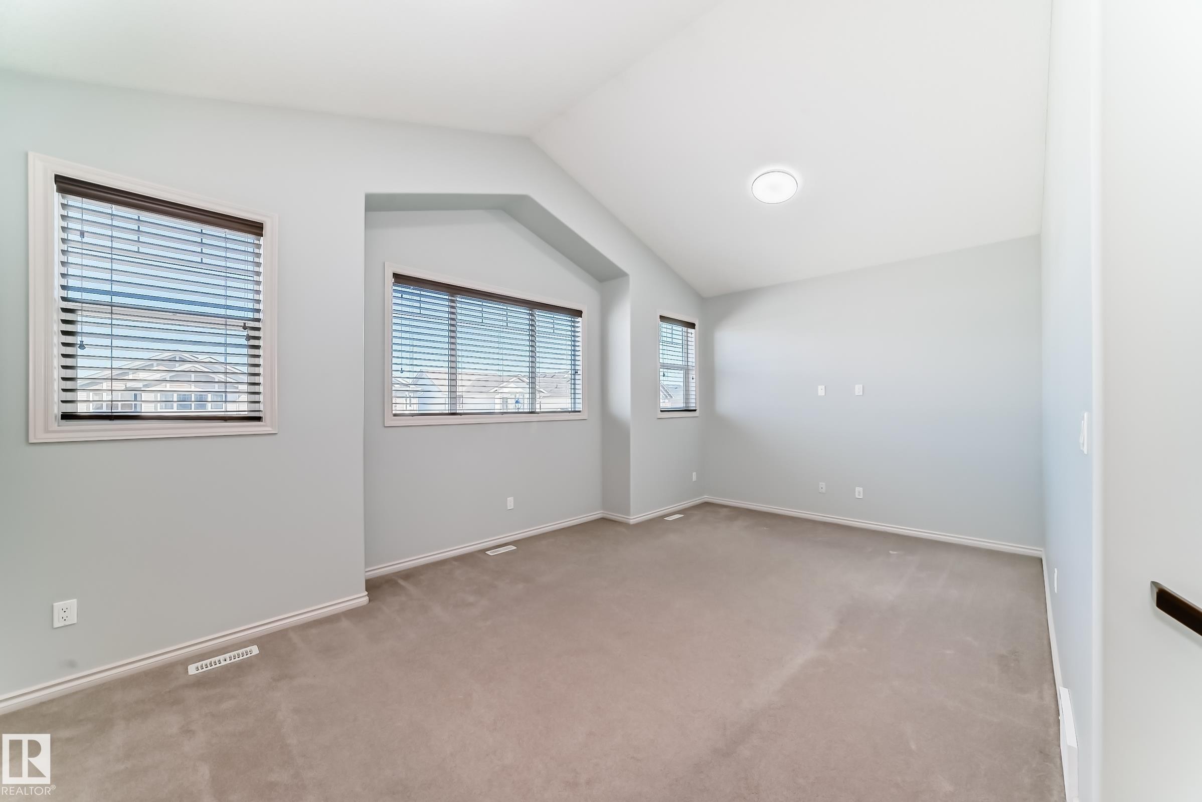 Spacious room featuring vaulted ceilings, light gray wall paint, and plush carpeting - 6723 19 Avenue, Edmonton, AB - Indoor Photo Showing Other Room