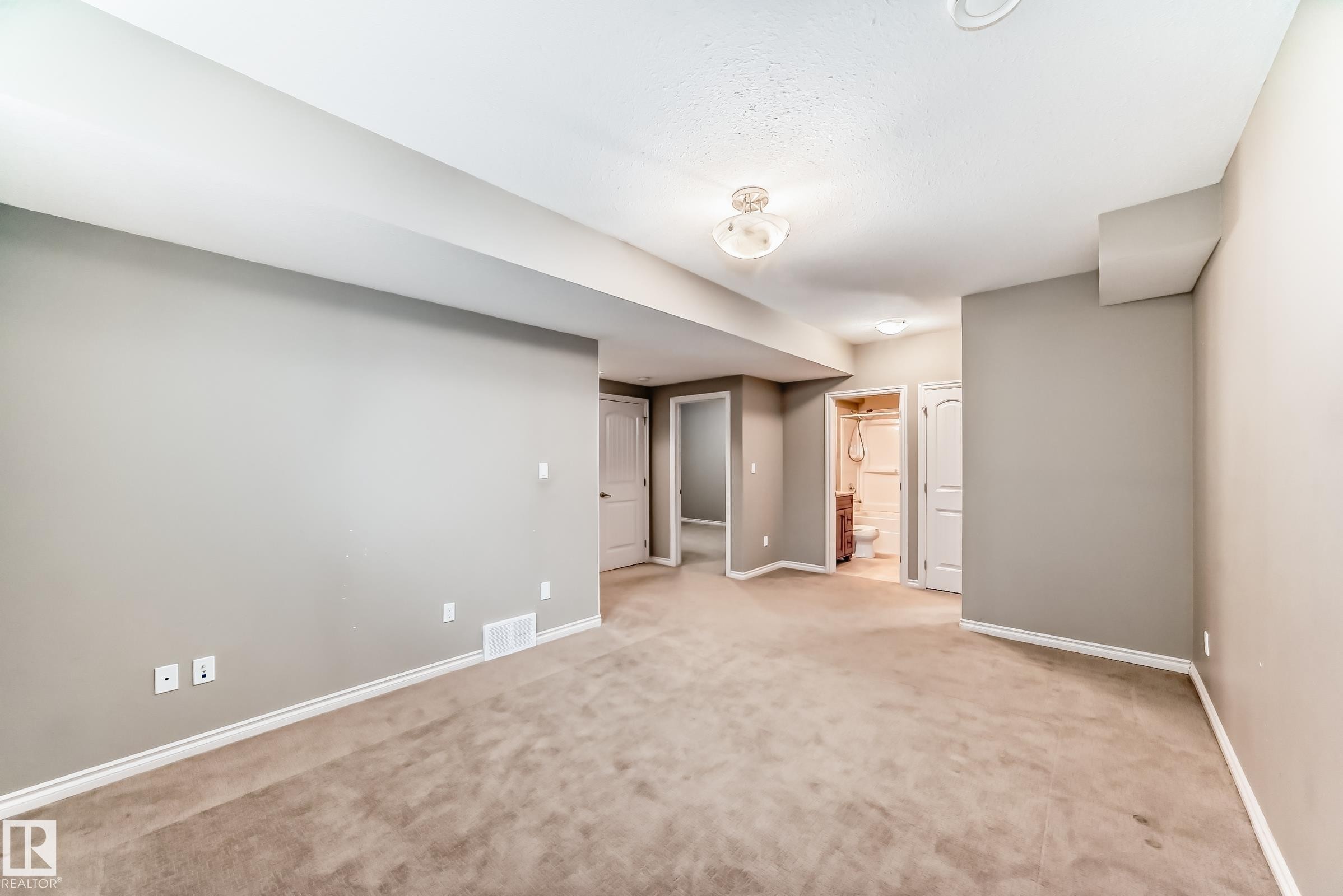 Spacious room featuring neutral carpeting, light gray walls, white baseboards, and a semi-flush mount ceiling light - 6723 19 Avenue, Edmonton, AB - Indoor Photo Showing Other Room