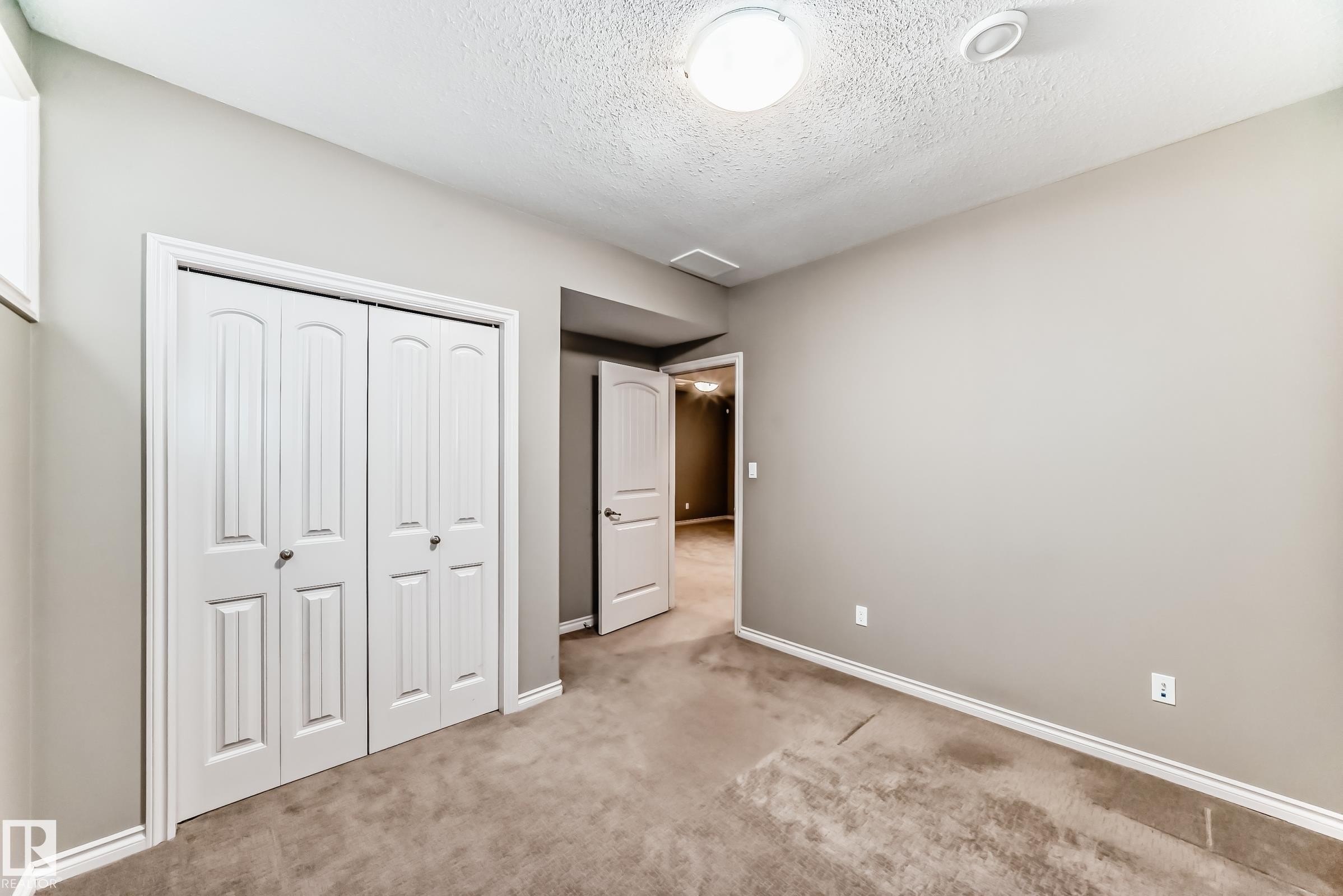 Room with neutral-toned walls, carpet flooring, a ceiling-mounted light fixture, and white bi-fold closet doors - 6723 19 Avenue, Edmonton, AB - Indoor