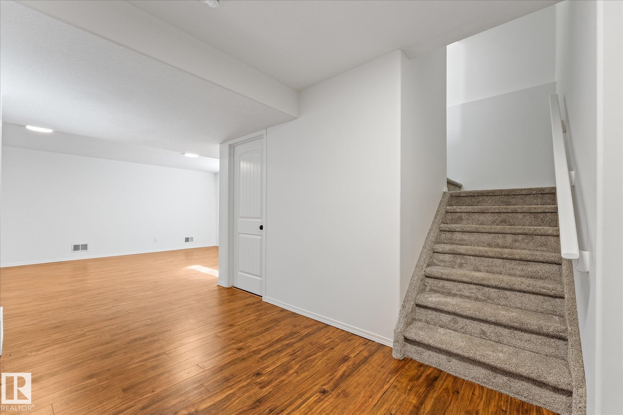 Spacious room featuring wood-finish flooring, white walls, and recessed lighting - 326 Silver Berry Road, Edmonton, AB - Indoor Photo Showing Other Room