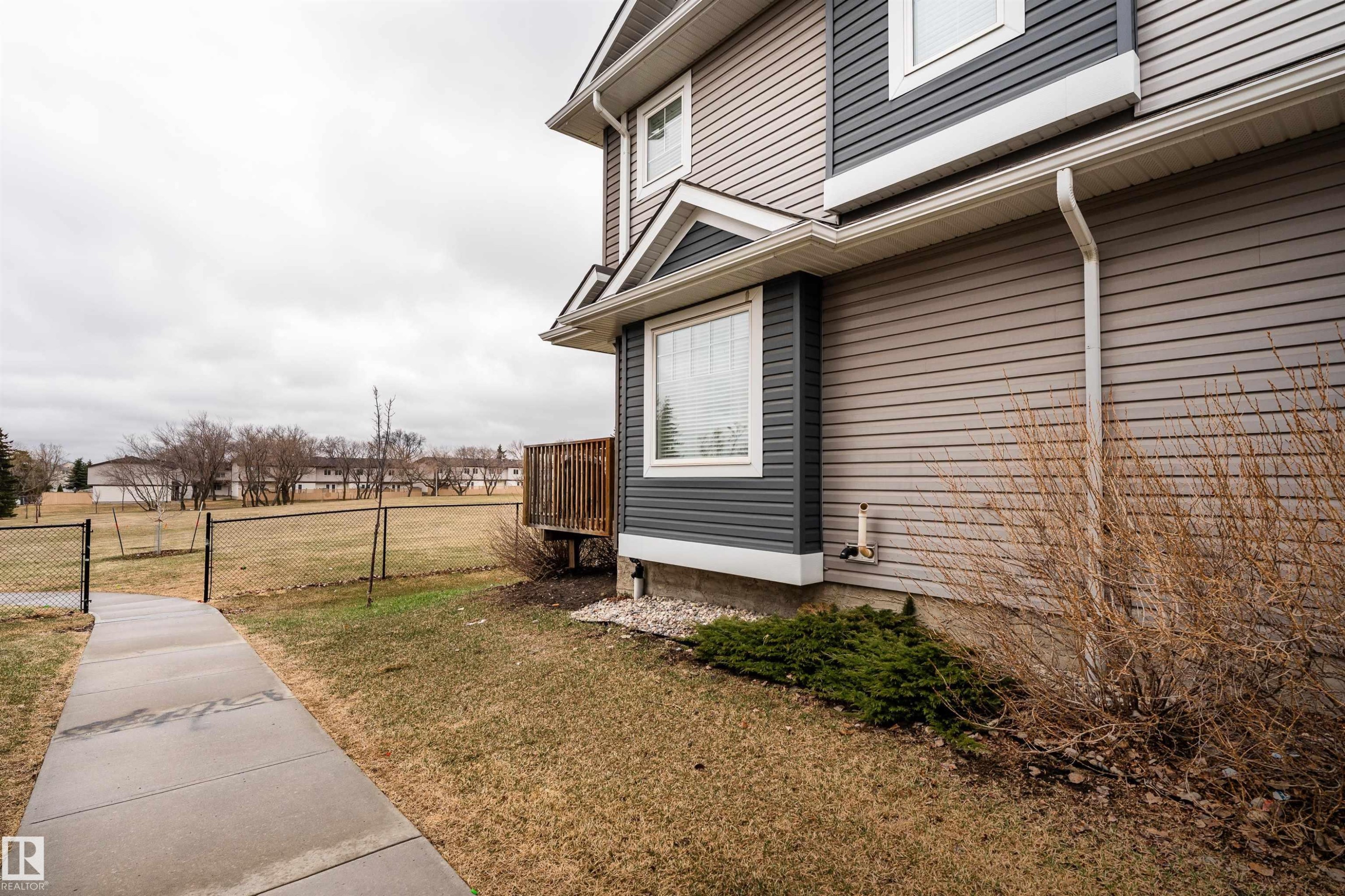 Two-story exterior featuring multi-toned siding, a bay window, and a wooden deck - 15 5203 149 Avenue, Edmonton, AB - Outdoor