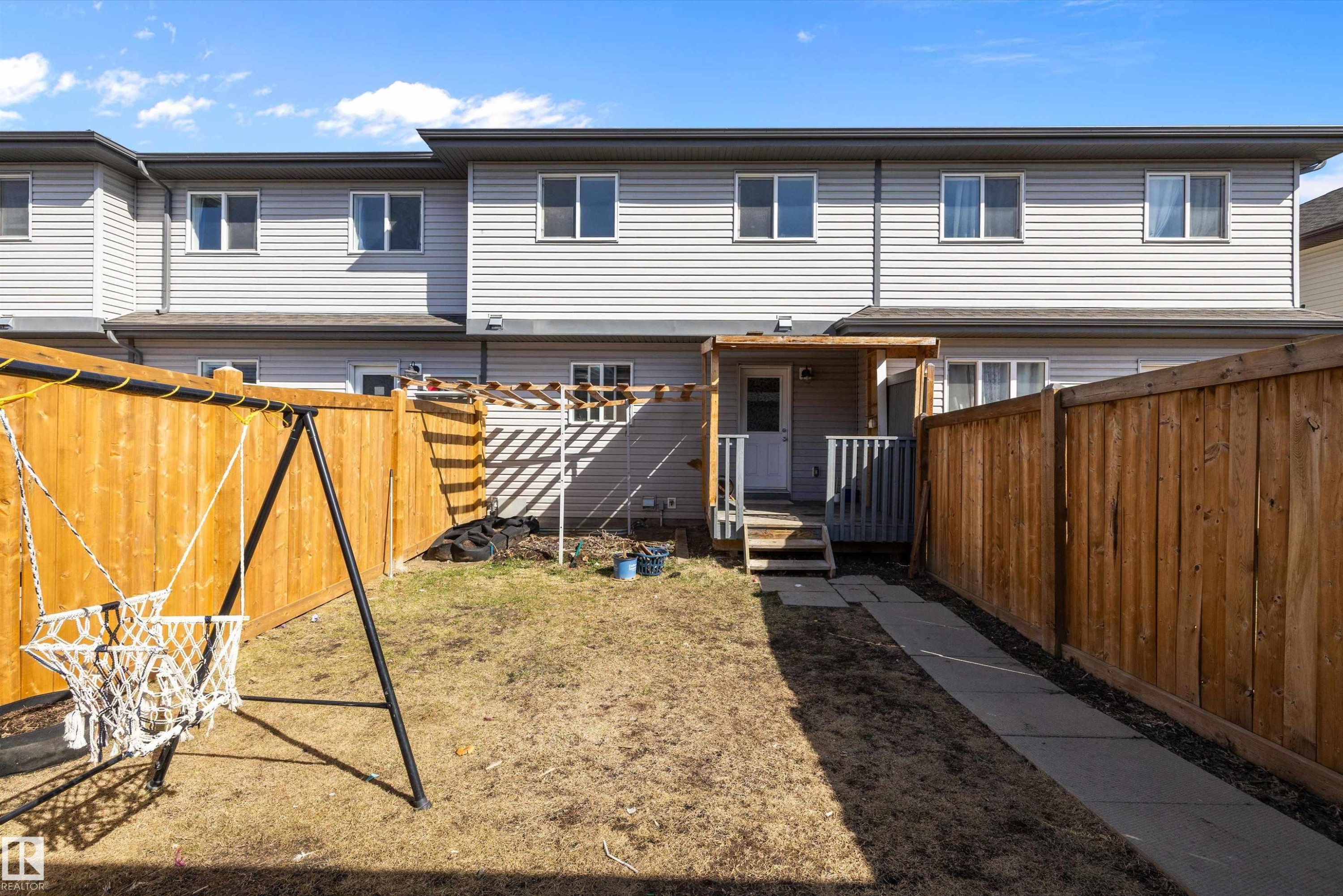 Private backyard featuring wood fencing and a concrete walkway - 2611 14 Avenue, Edmonton, AB - Outdoor With Exterior