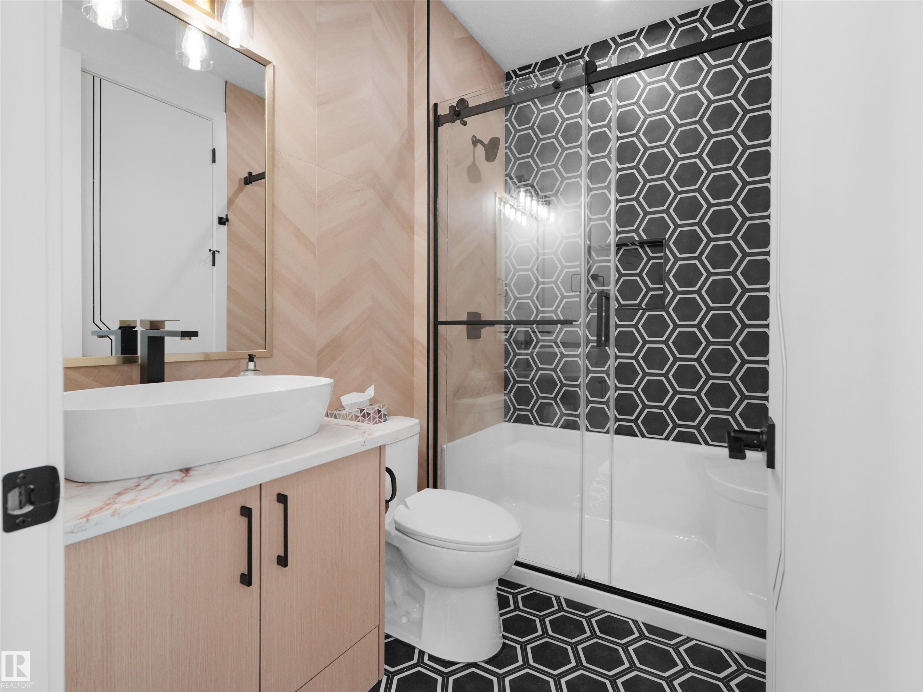 Bathroom featuring a vessel sink with a matte black faucet, light wood-finish vanity with black hardware, and a marble-look countertop - 2070 Collip Crescent Sw, Edmonton, AB - Indoor Photo Showing Bathroom