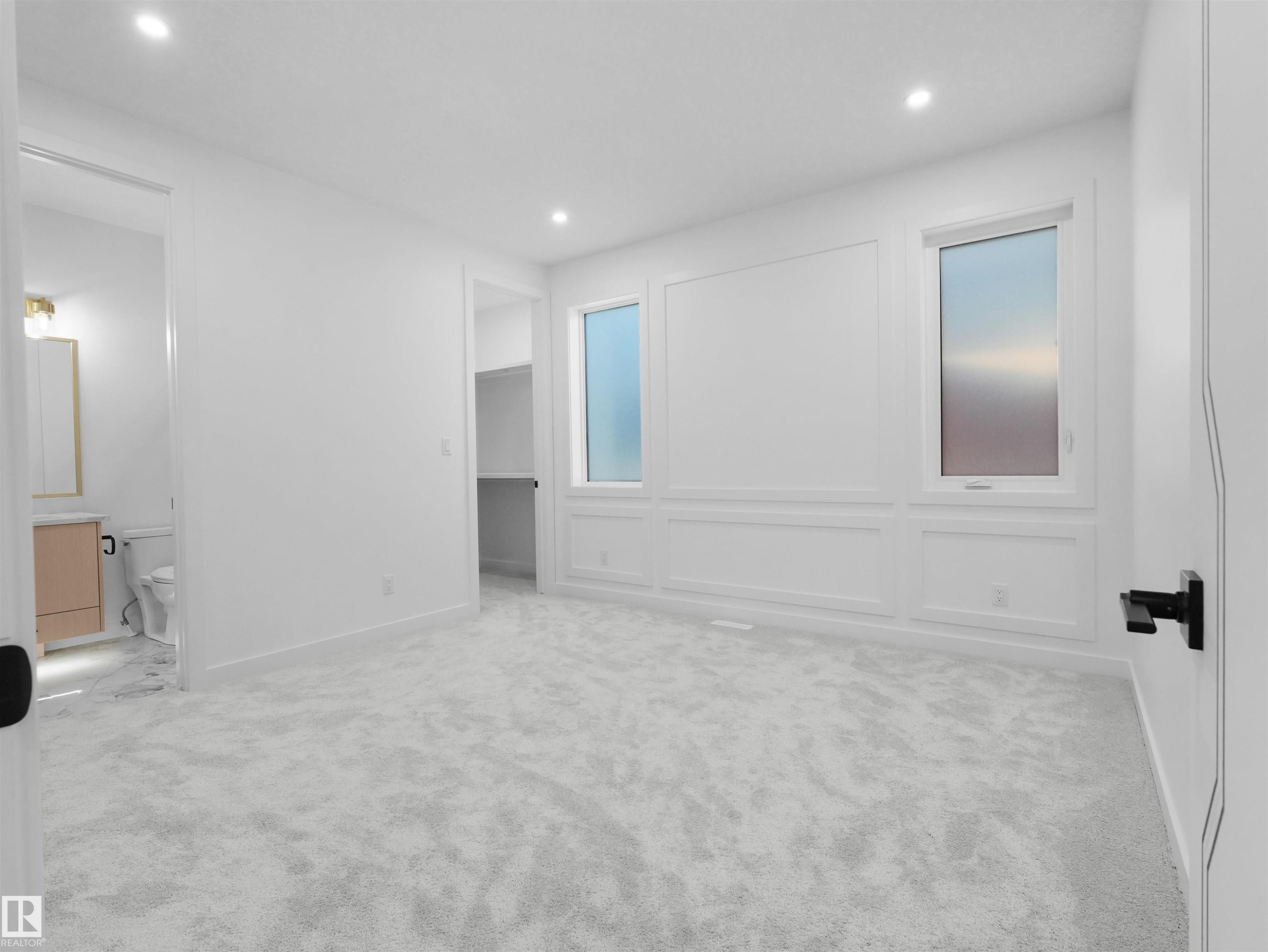 Spacious room with light-toned carpet flooring, recessed lighting, and decorative wall paneling - 2070 Collip Crescent Sw, Edmonton, AB - Indoor Photo Showing Other Room