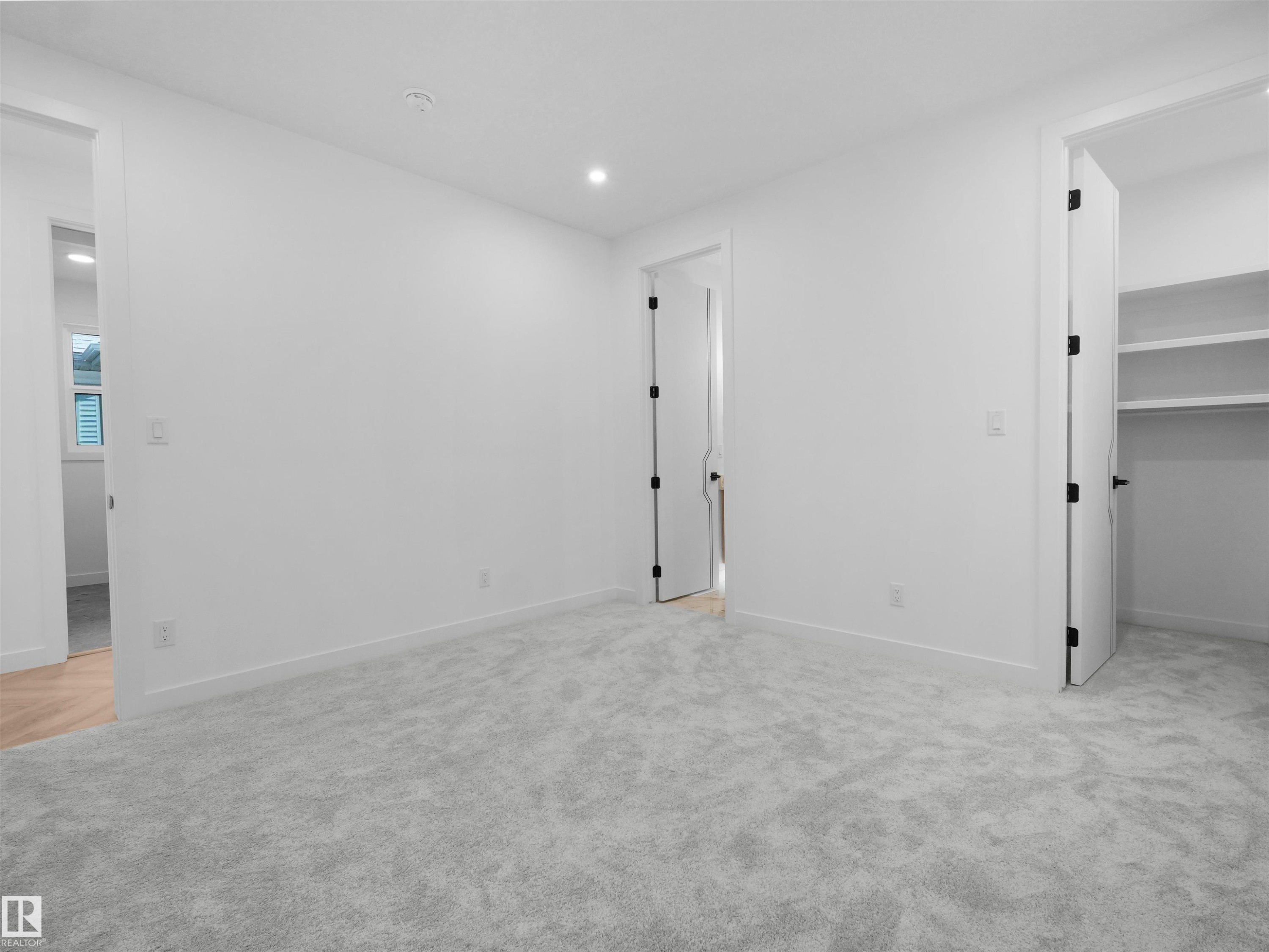 Neutral-toned wall-to-wall carpeting complements bright white walls and trim - 2070 Collip Crescent Sw, Edmonton, AB - Indoor Photo Showing Other Room