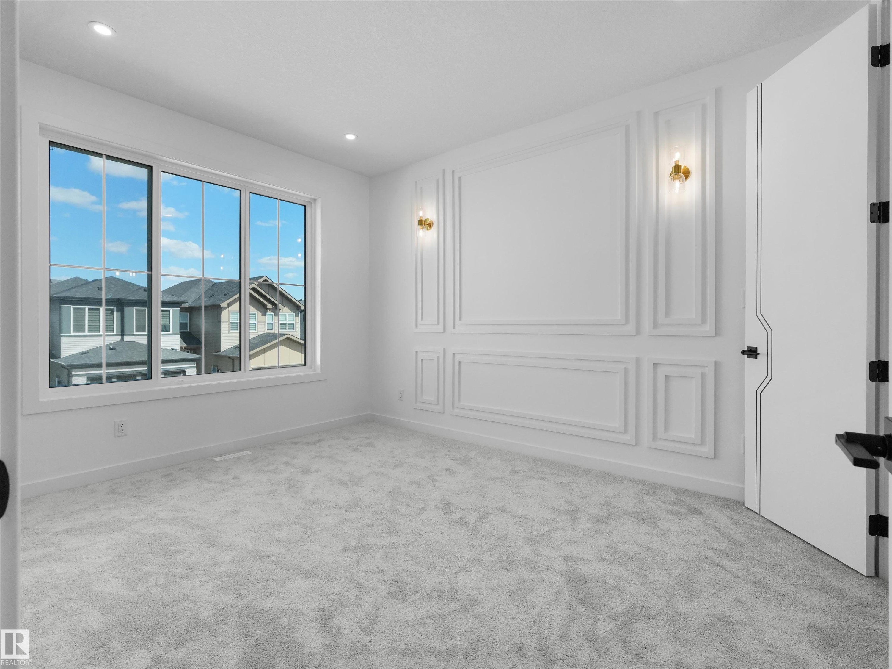 Spacious bedroom featuring a multi-pane window, decorative wall molding with sconces, recessed ceiling lighting, and light-toned carpet flooring - 2070 Collip Crescent Sw, Edmonton, AB - Indoor Photo Showing Other Room