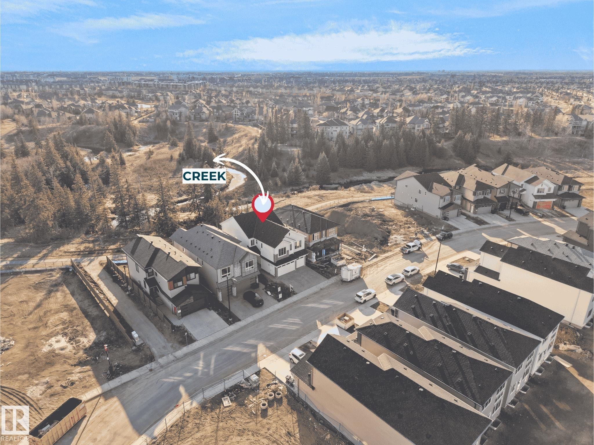 Aerial perspective showcasing a residential development with a prominent creek - 2070 Collip Crescent Sw, Edmonton, AB - Outdoor With View