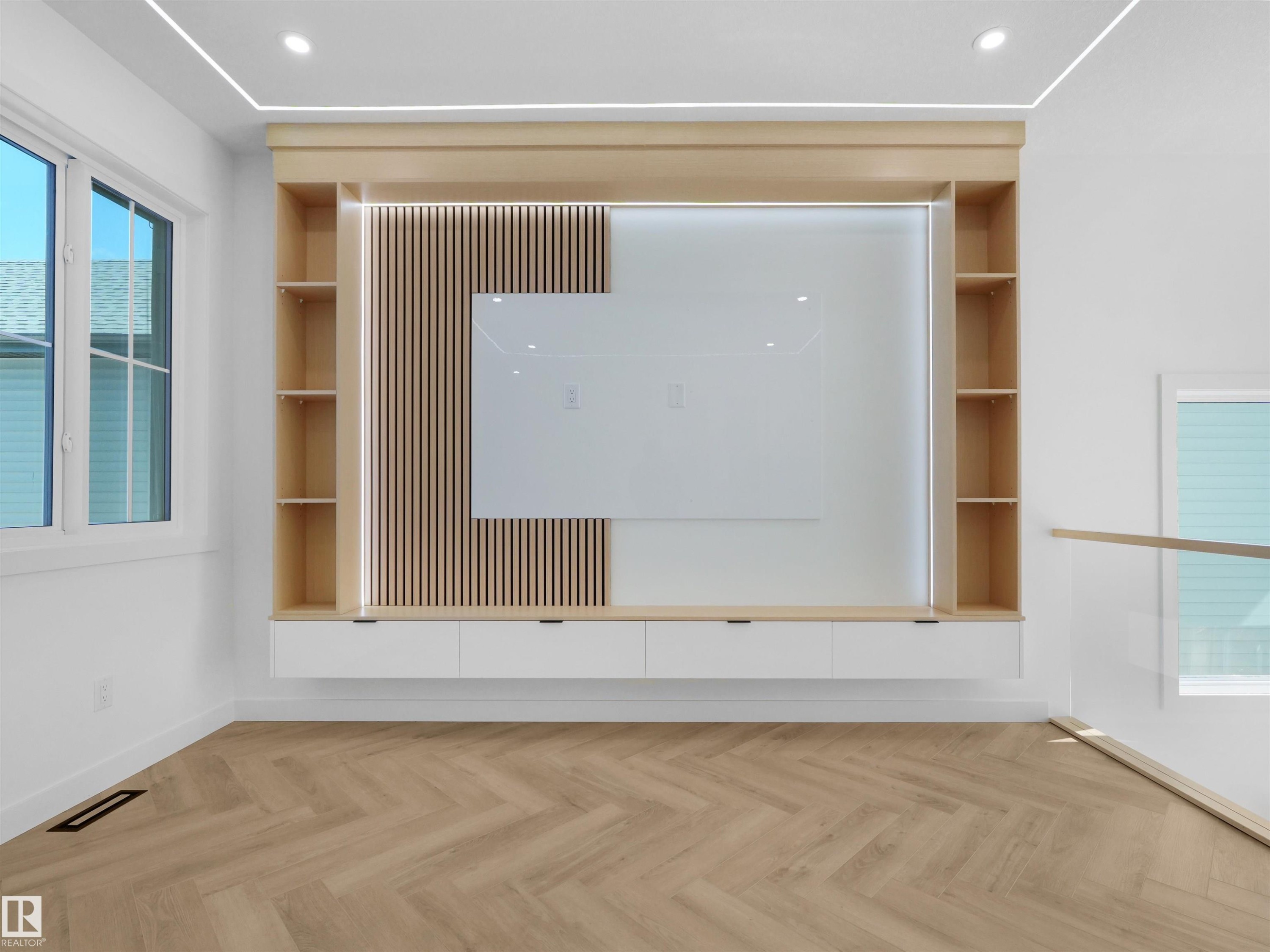Built-in entertainment center featuring light wood-finish cabinetry, integrated shelving, and a slatted wood accent wall - 2070 Collip Crescent Sw, Edmonton, AB - Indoor Photo Showing Other Room