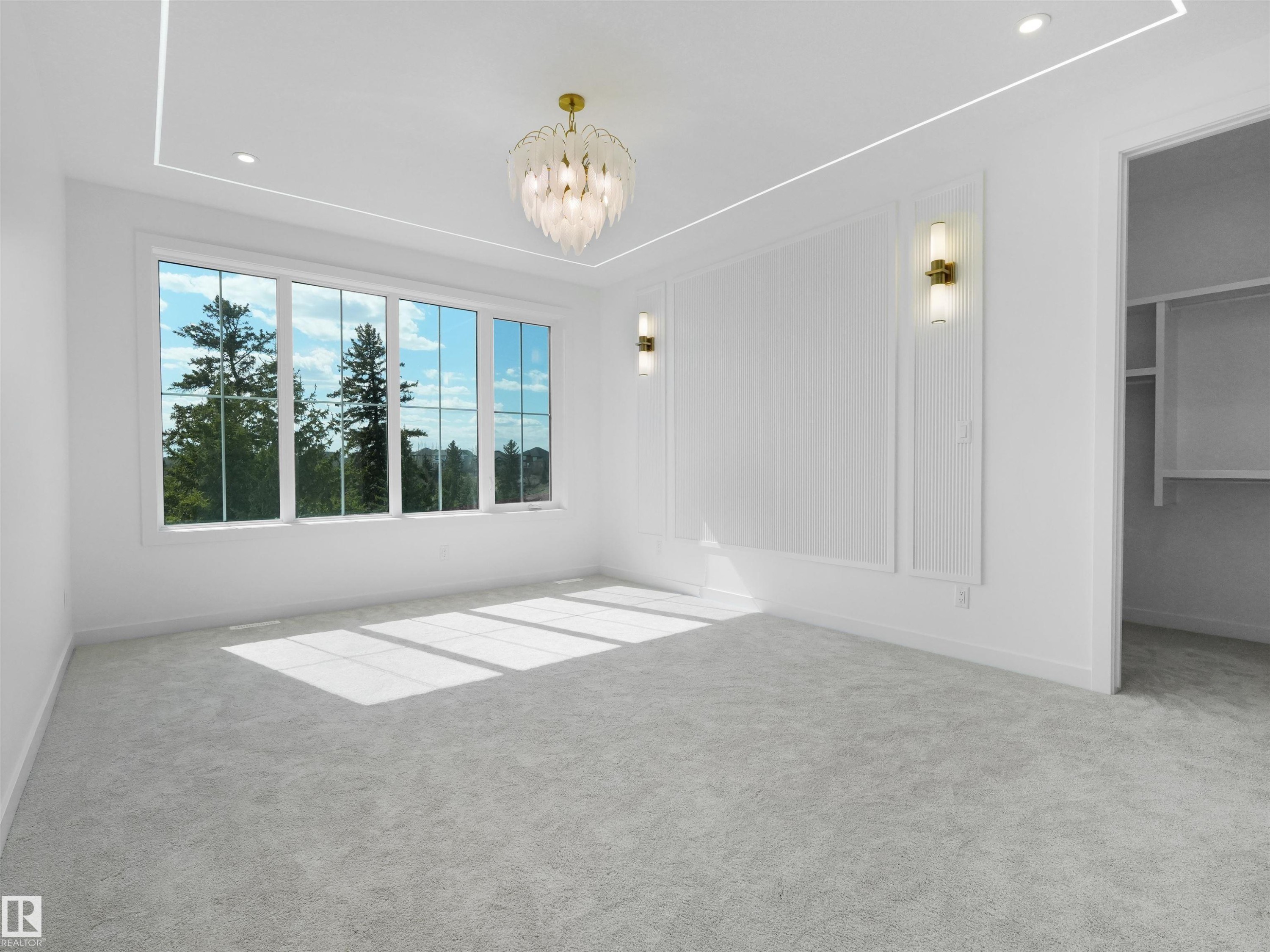 Bright primary bedroom with broad windows, light gray carpet, recessed lighting, and a decorative ceiling fixture - 2070 Collip Crescent Sw, Edmonton, AB - Indoor