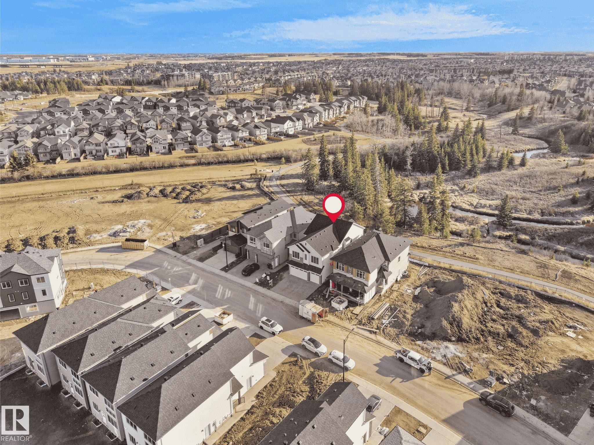 Contemporary residential property featuring a multiple-gabled roofline and light-toned siding - 2070 Collip Crescent Sw, Edmonton, AB - Outdoor With View