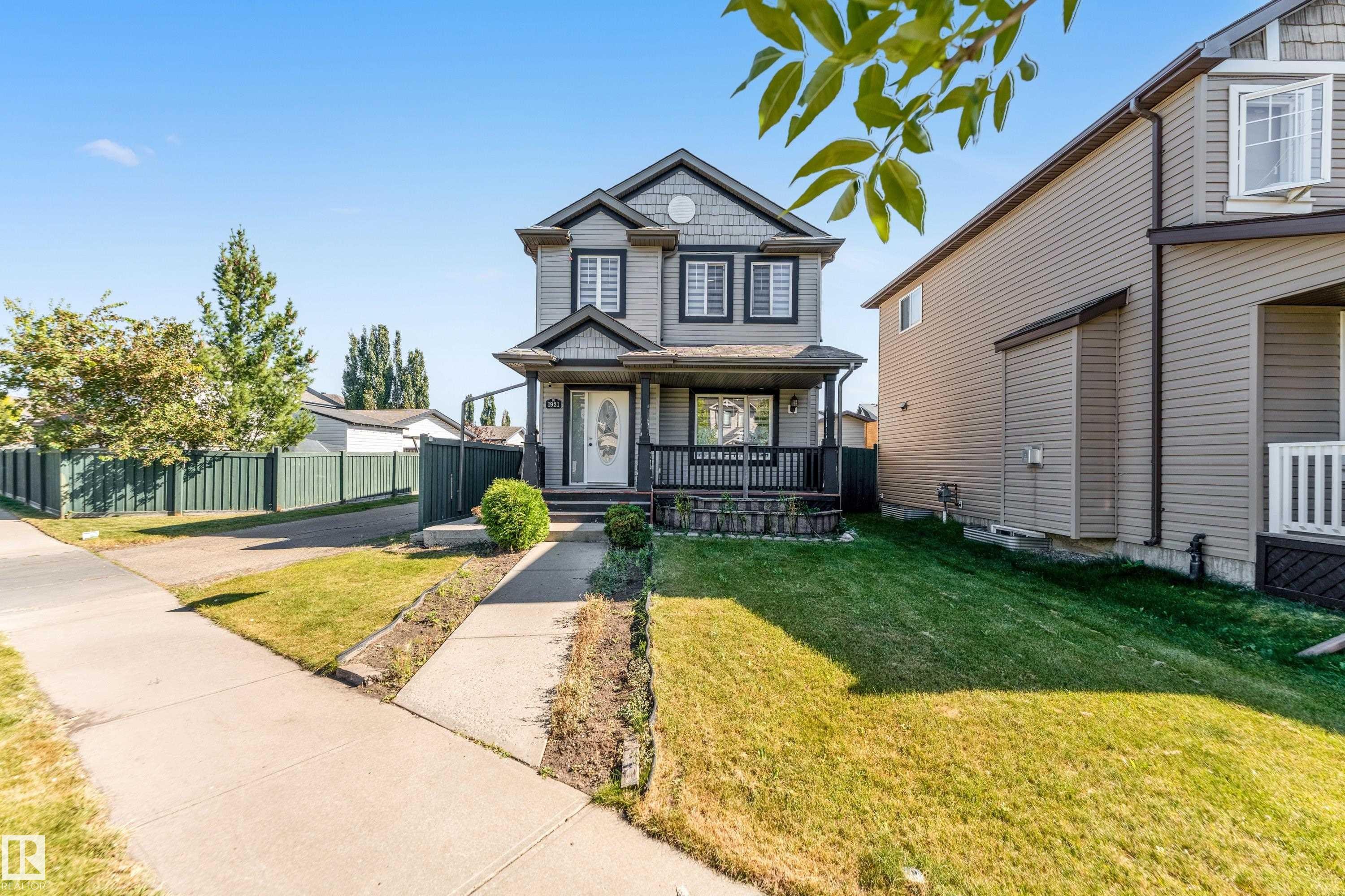Inviting two-story residence with a gray exterior, dark trim accents, and a covered front porch - 1921 119A Street, Edmonton, AB