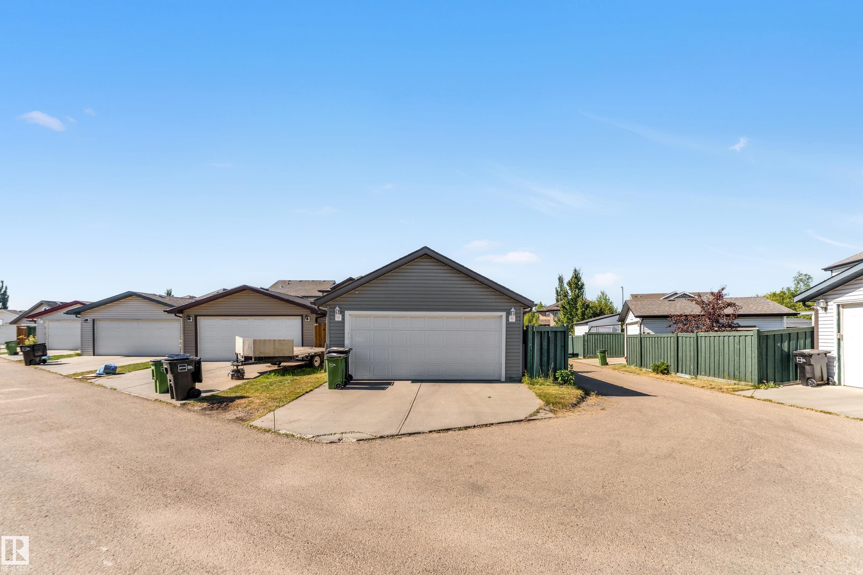 Detached garage with horizontal siding and a white overhead door - 1921 119A Street, Edmonton, AB