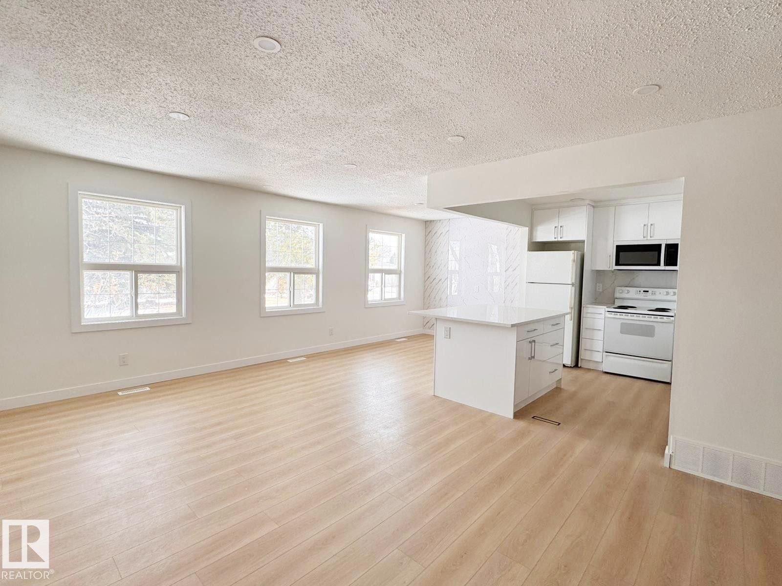 Open-concept living space featuring wood-finish flooring, recessed lighting, and multiple windows - 20 Hunt Road, Edmonton, AB - Indoor Photo Showing Kitchen