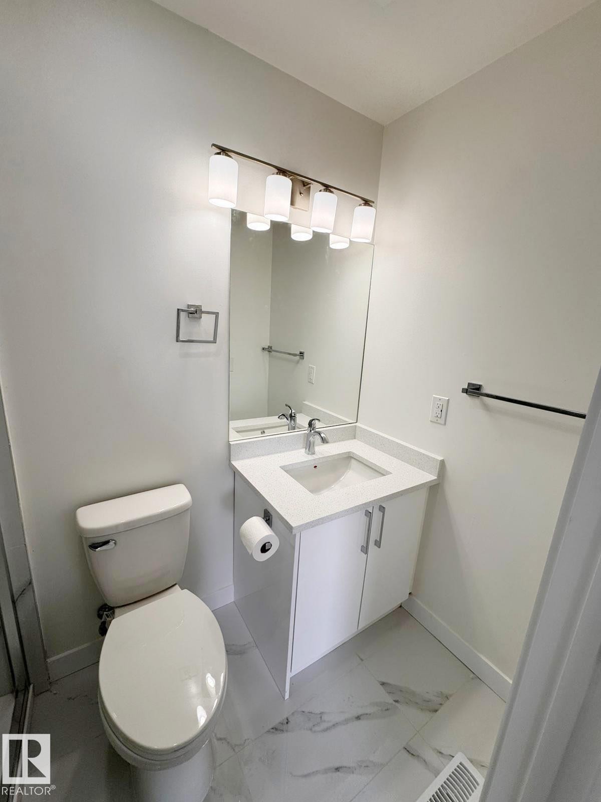 Bathroom featuring a white vanity with an integrated sink, polished chrome faucet, and white countertop - 20 Hunt Road, Edmonton, AB - Indoor Photo Showing Bathroom