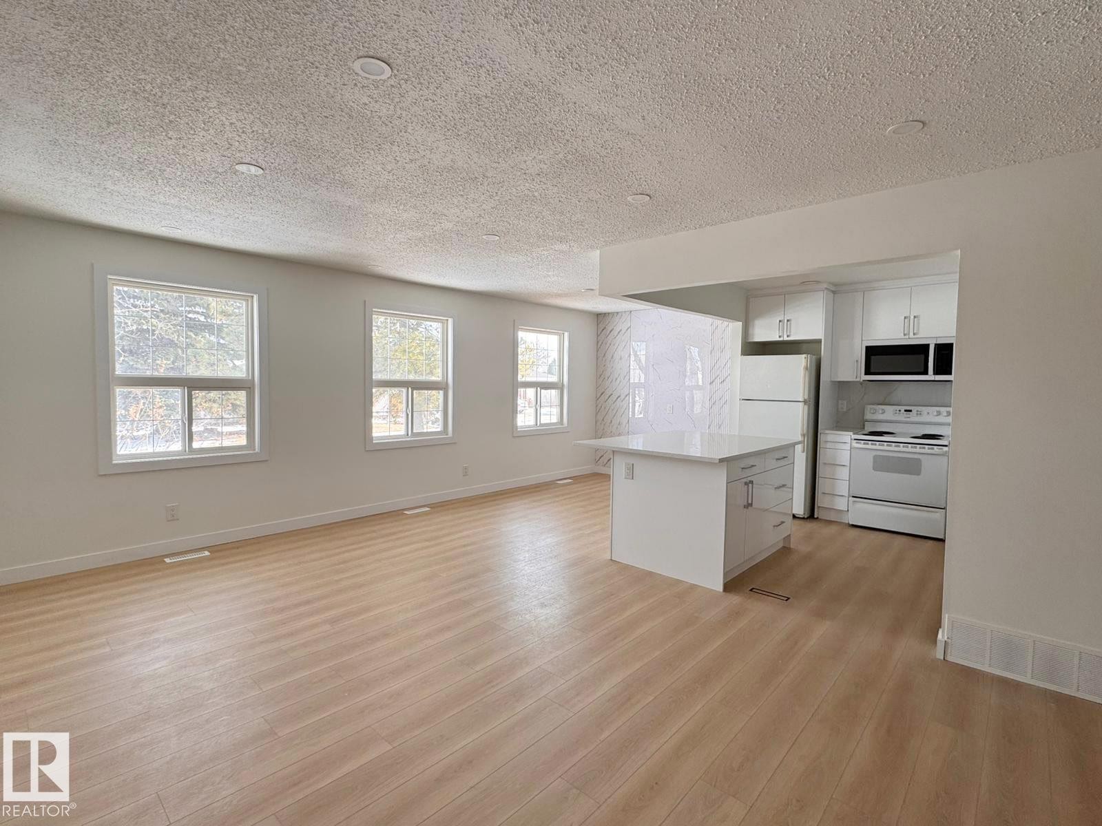 Open-concept living space featuring wood-finish flooring, recessed lighting, and multiple windows - 20 Hunt Road, Edmonton, AB - Indoor Photo Showing Kitchen