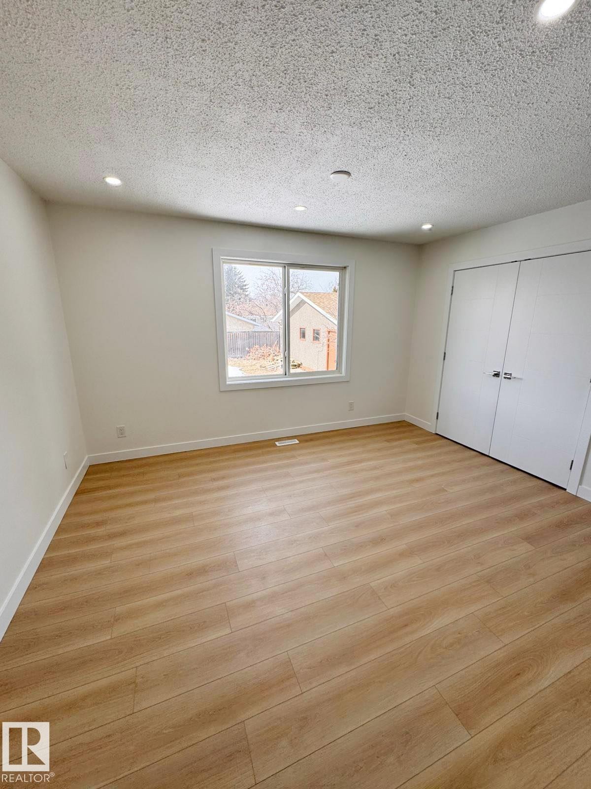 Spacious room featuring light wood-finish flooring, recessed lighting, and a neutral wall palette - 20 Hunt Road, Edmonton, AB - Indoor Photo Showing Other Room