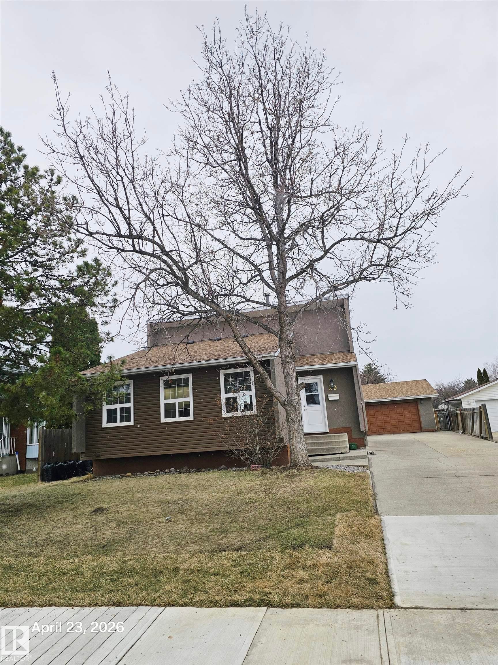 Brown siding exterior with white window trim and a concrete driveway - 20 Hunt Road, Edmonton, AB - Outdoor