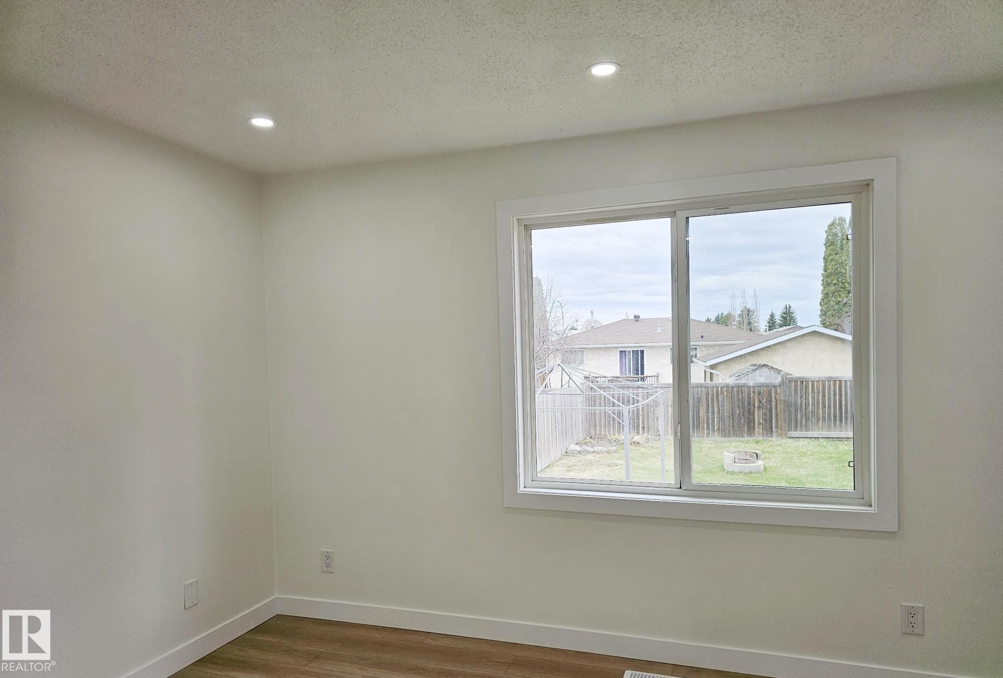 Bright interior space featuring a large sliding window with white trim - 20 Hunt Road, Edmonton, AB - Indoor Photo Showing Other Room