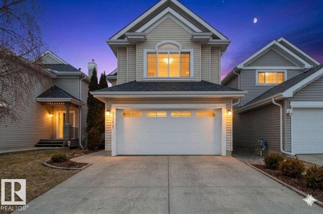 Exterior featuring a two-story design with light-toned siding, an attached garage, a paved driveway, and a covered entry porch - 8311 11 Avenue, Edmonton, AB - Outdoor