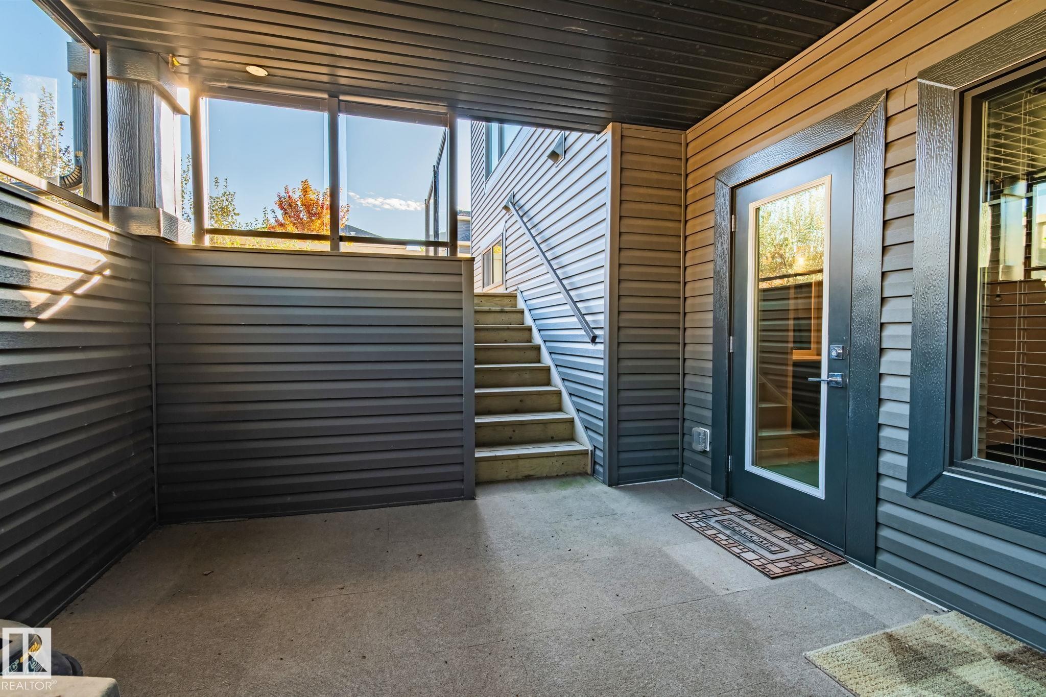 Covered concrete patio with horizontal siding and exterior lighting - 67 Enchanted Way Nw, St. Albert, AB - Outdoor With Deck Patio Veranda With Exterior