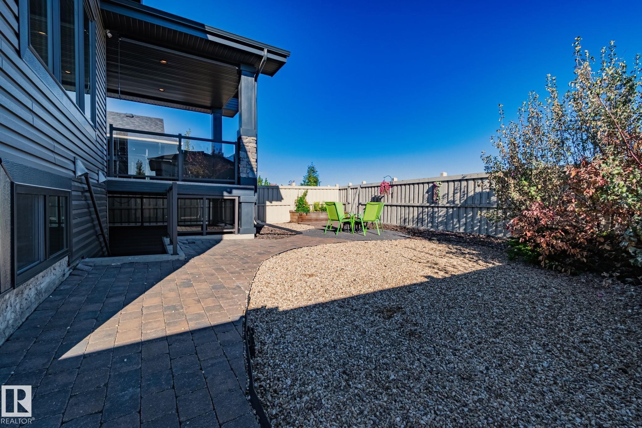 Exterior featuring dark siding and a covered upper deck with glass railings - 67 Enchanted Way Nw, St. Albert, AB - Outdoor