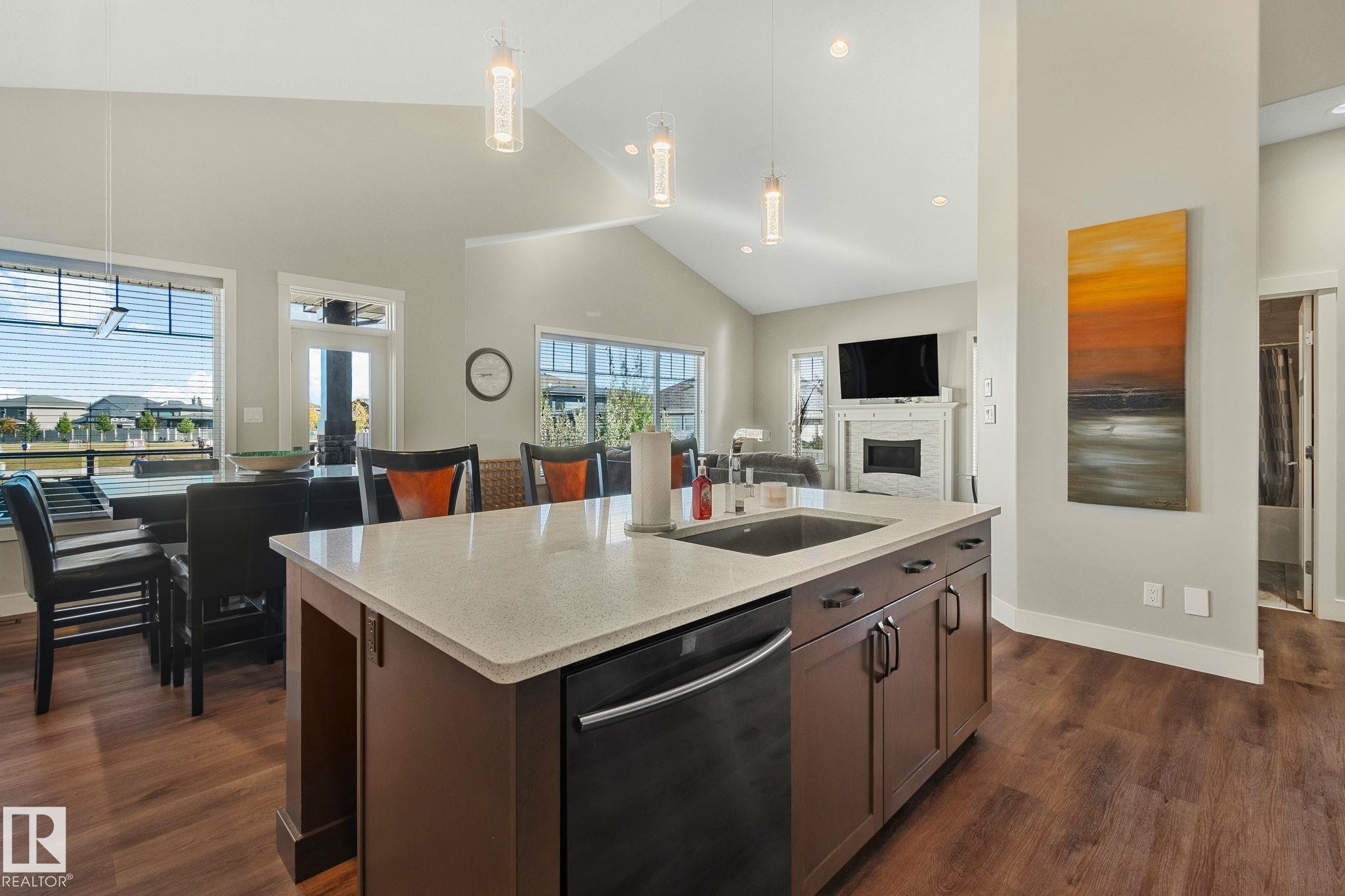Kitchen island featuring a single-bowl sink, built-in dishwasher, and light-toned countertop - 67 Enchanted Way Nw, St. Albert, AB - Indoor
