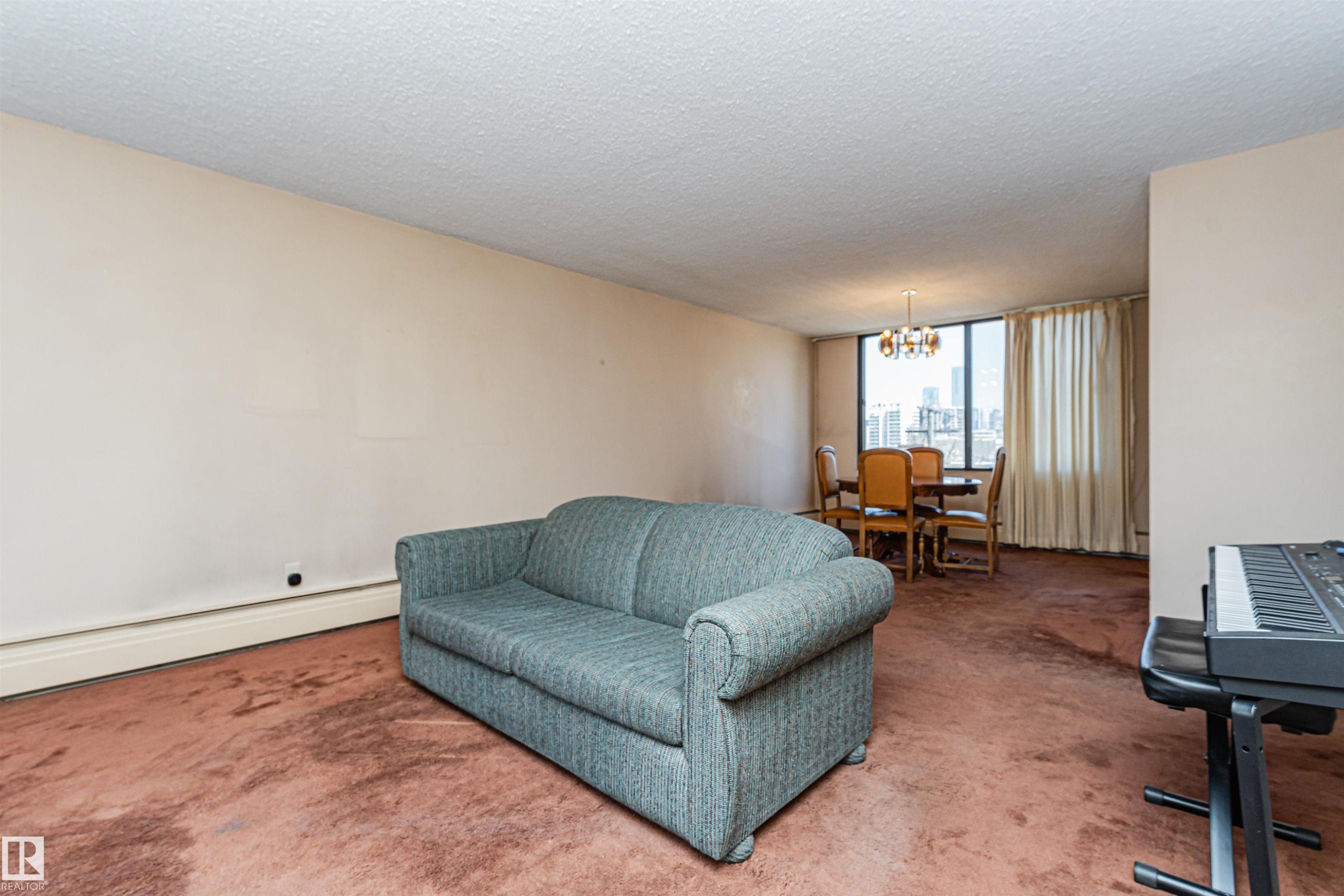 Open-concept living and dining area featuring warm neutral wall tones and a textured ceiling - 407 10045 118 Street, Edmonton, AB - Indoor Photo Showing Living Room