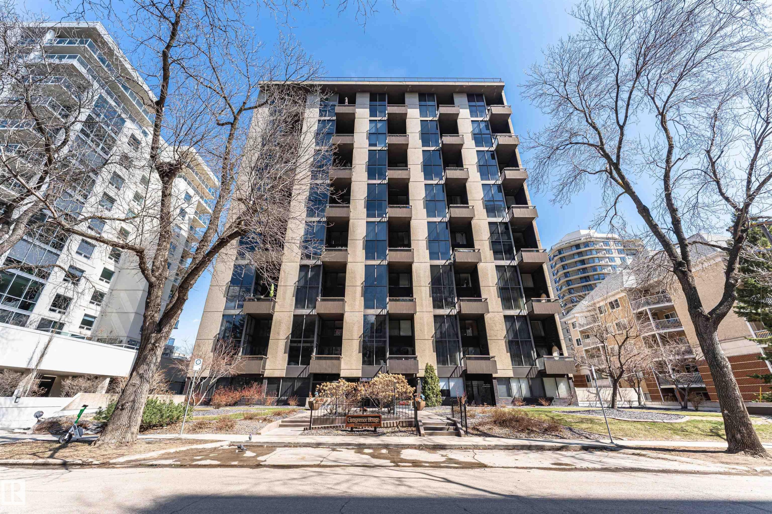 Multi-story building featuring a facade with dark window panels and light-colored vertical elements - 407 10045 118 Street, Edmonton, AB - Outdoor With Facade