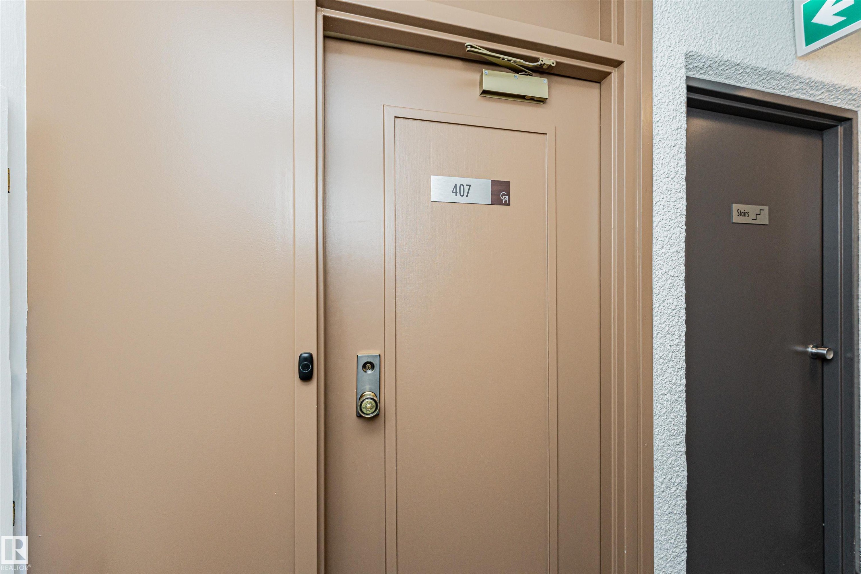 Entry door with brass hardware and a privacy peephole - 407 10045 118 Street, Edmonton, AB - Photo Showing Other Room