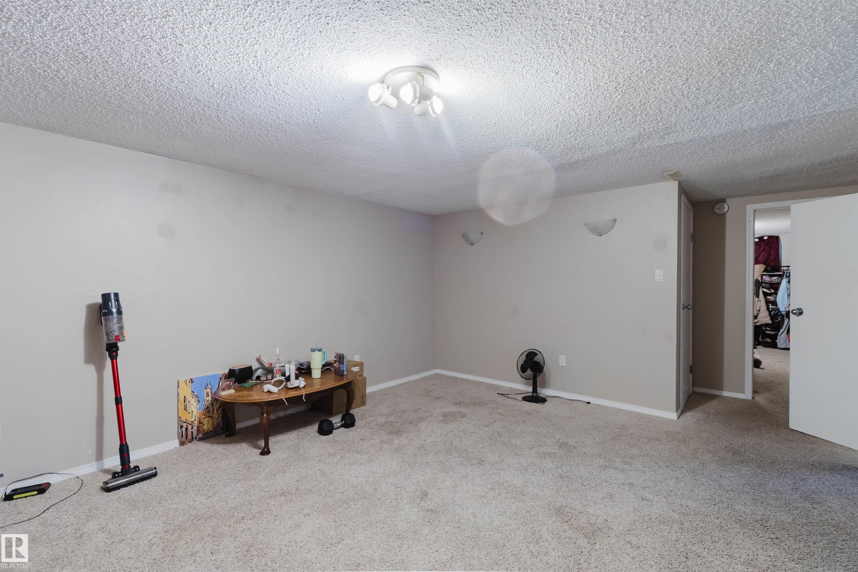 Carpeted room featuring neutral wall tones and a textured ceiling - 10519 36A Avenue, Edmonton, AB - Indoor