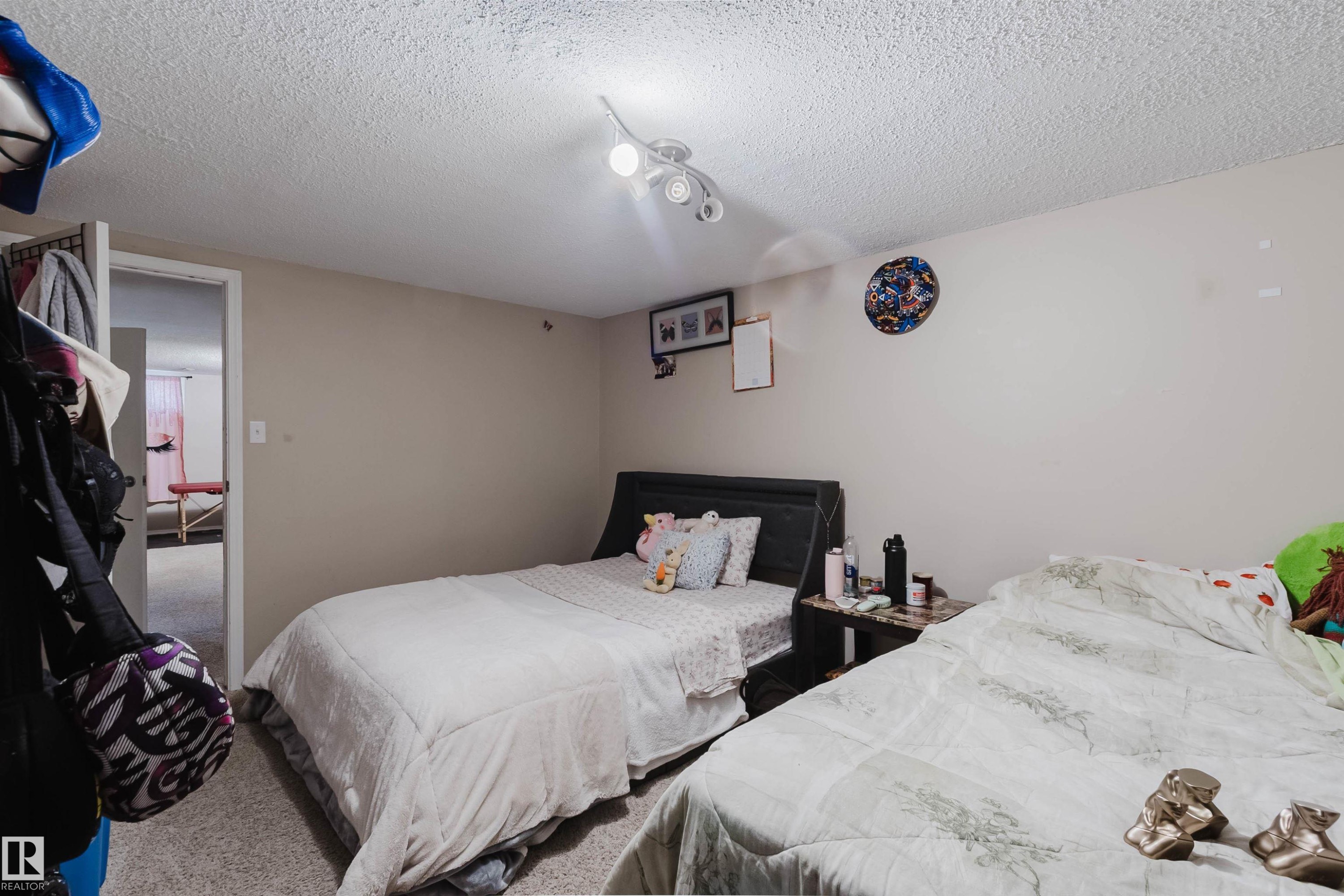 Spacious room featuring neutral paint, textured ceiling, and a flush-mount ceiling fixture with multiple lights - 10519 36A Avenue, Edmonton, AB - Indoor Photo Showing Bedroom