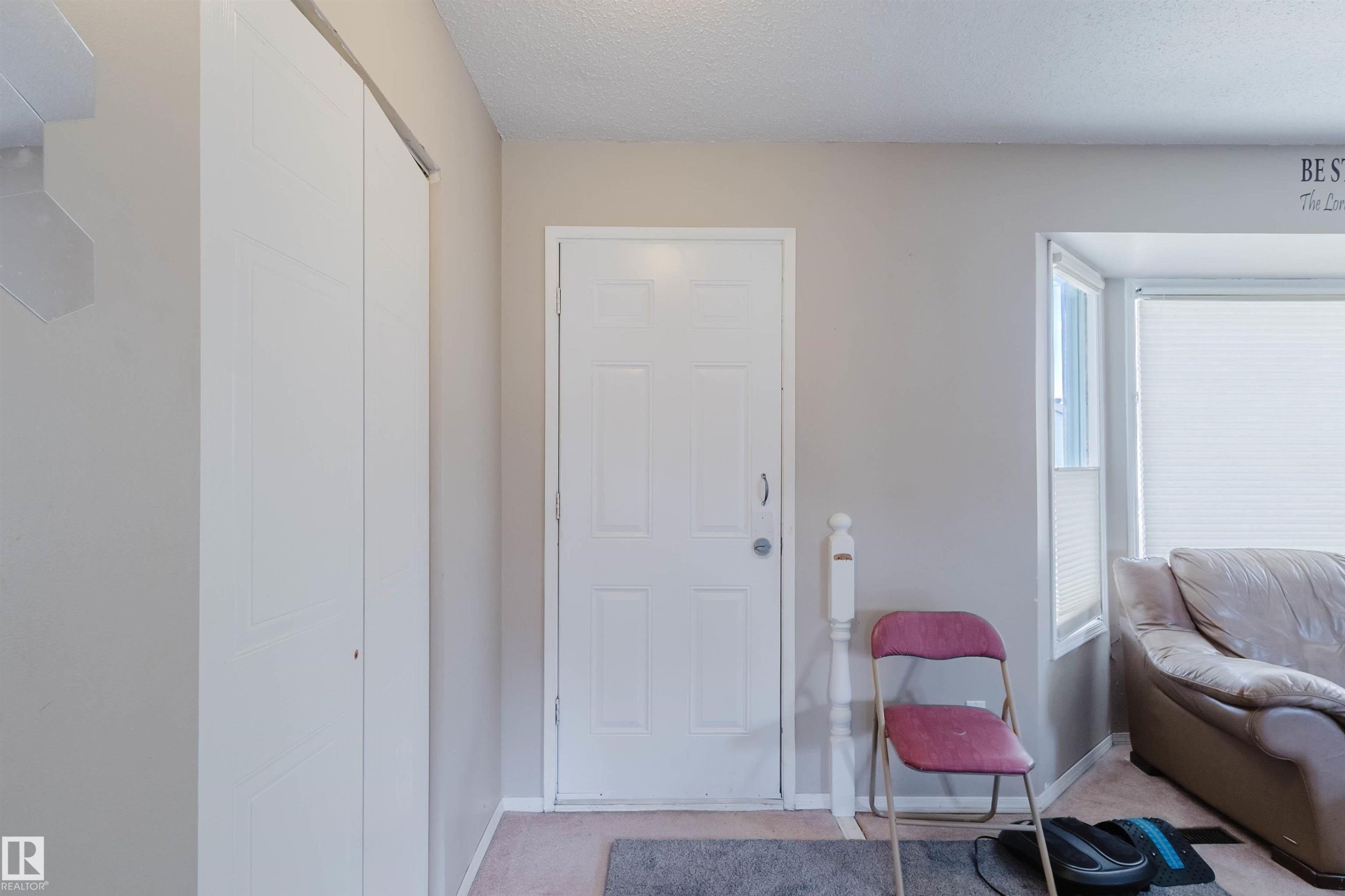 Entryway featuring a white paneled door, light-colored walls, and a multi-panel bifold closet - 10519 36A Avenue, Edmonton, AB - Indoor Photo Showing Other Room