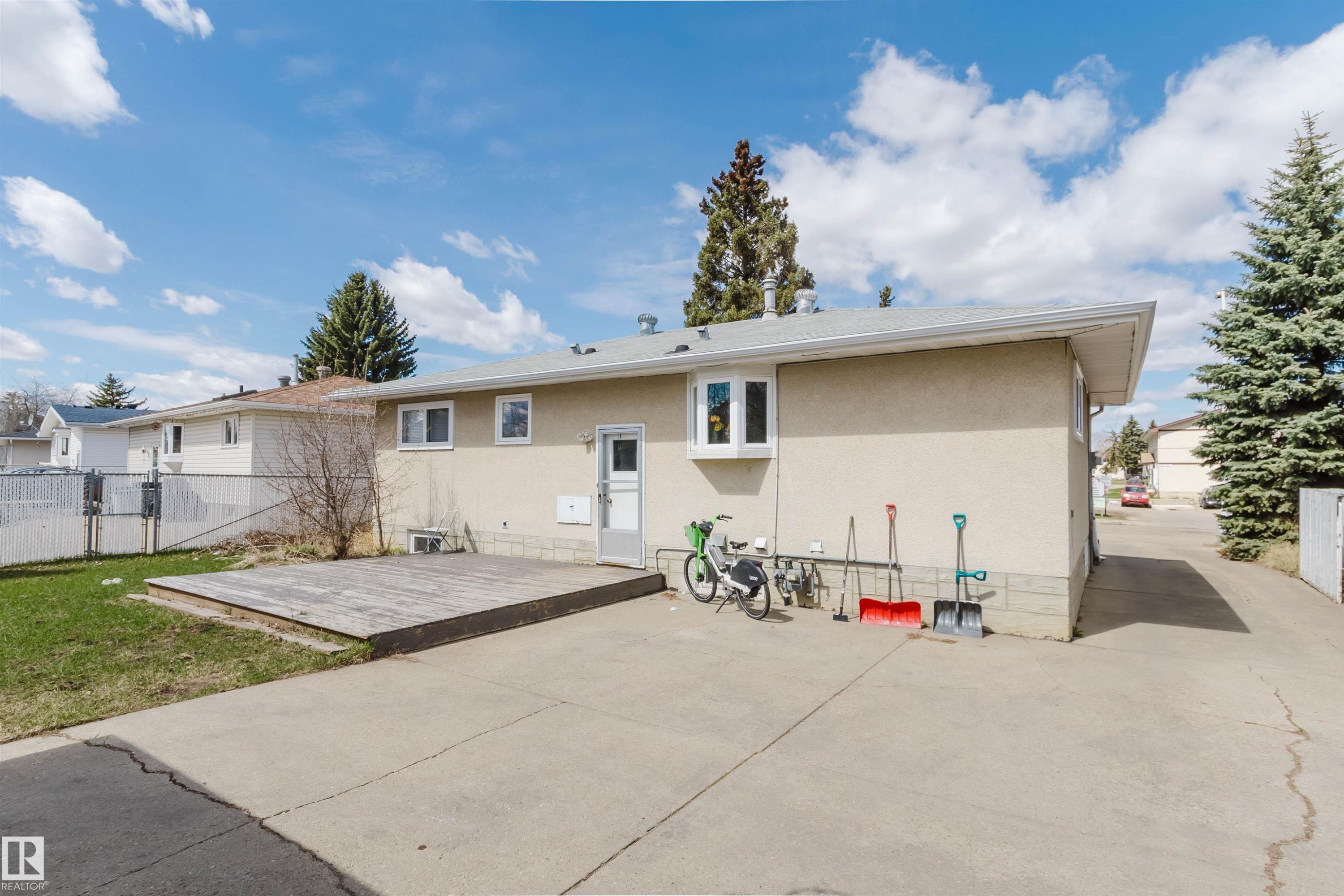 Rear exterior featuring a stucco finish, multiple windows, and a bay window - 10519 36A Avenue, Edmonton, AB - Outdoor