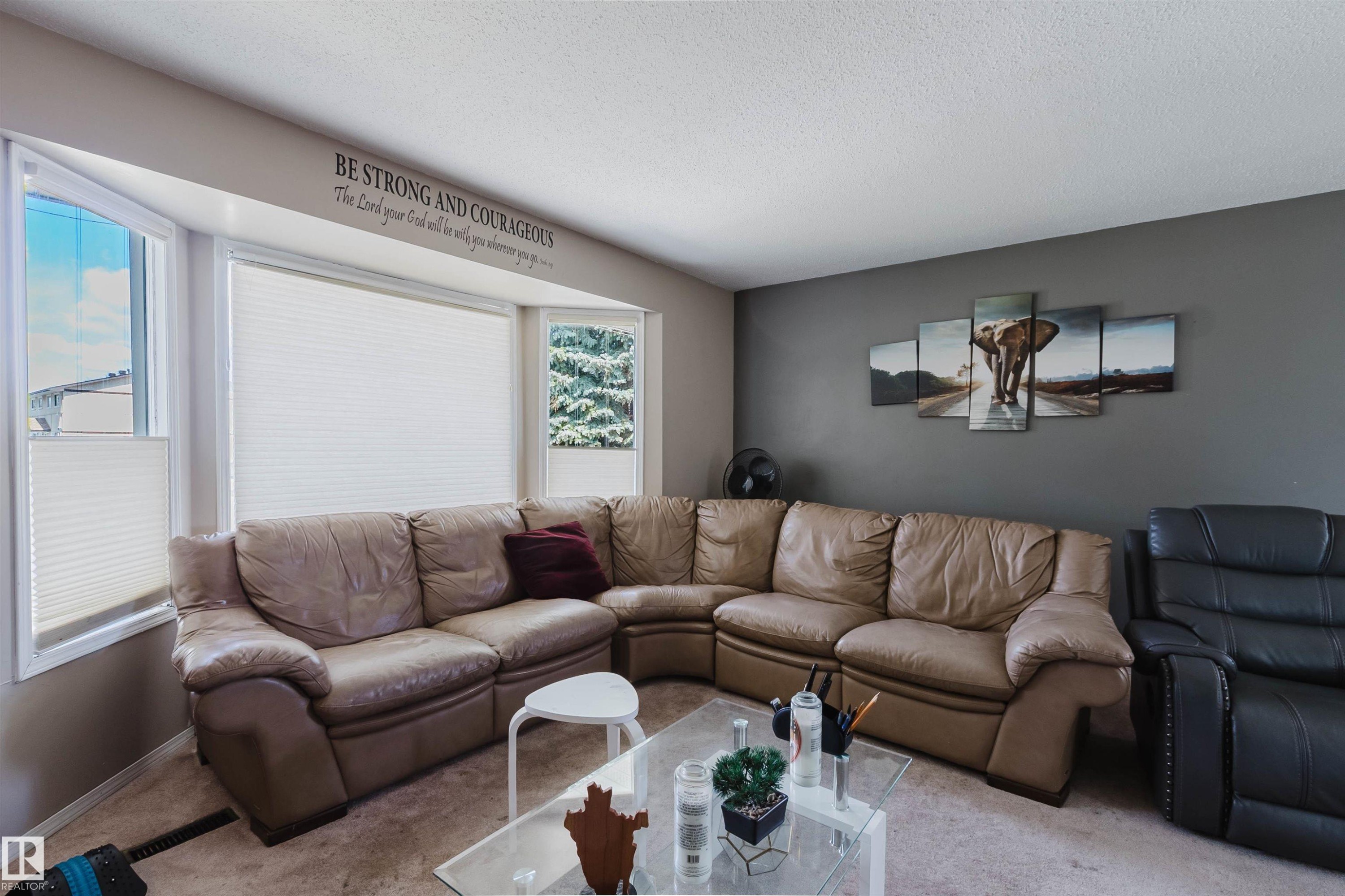 Bright living area with a large bay window, neutral-toned walls, and carpet flooring - 10519 36A Avenue, Edmonton, AB - Indoor Photo Showing Living Room