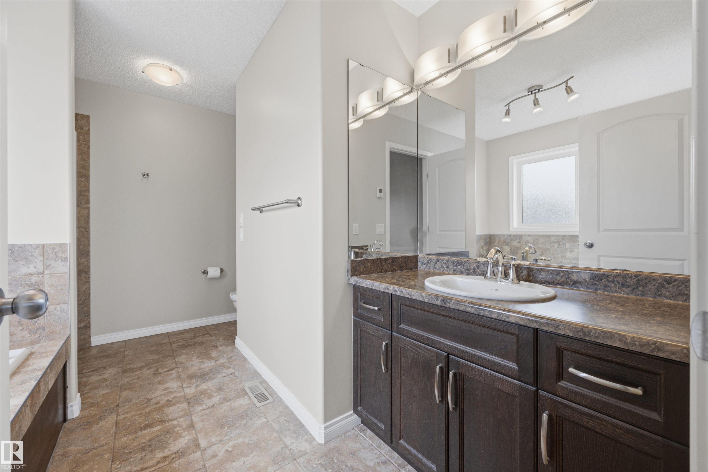 Ensuite 4-PC bath off the primary bedroom with in-floor heating. - 20813 96A Avenue, Edmonton, AB - Indoor Photo Showing Bathroom