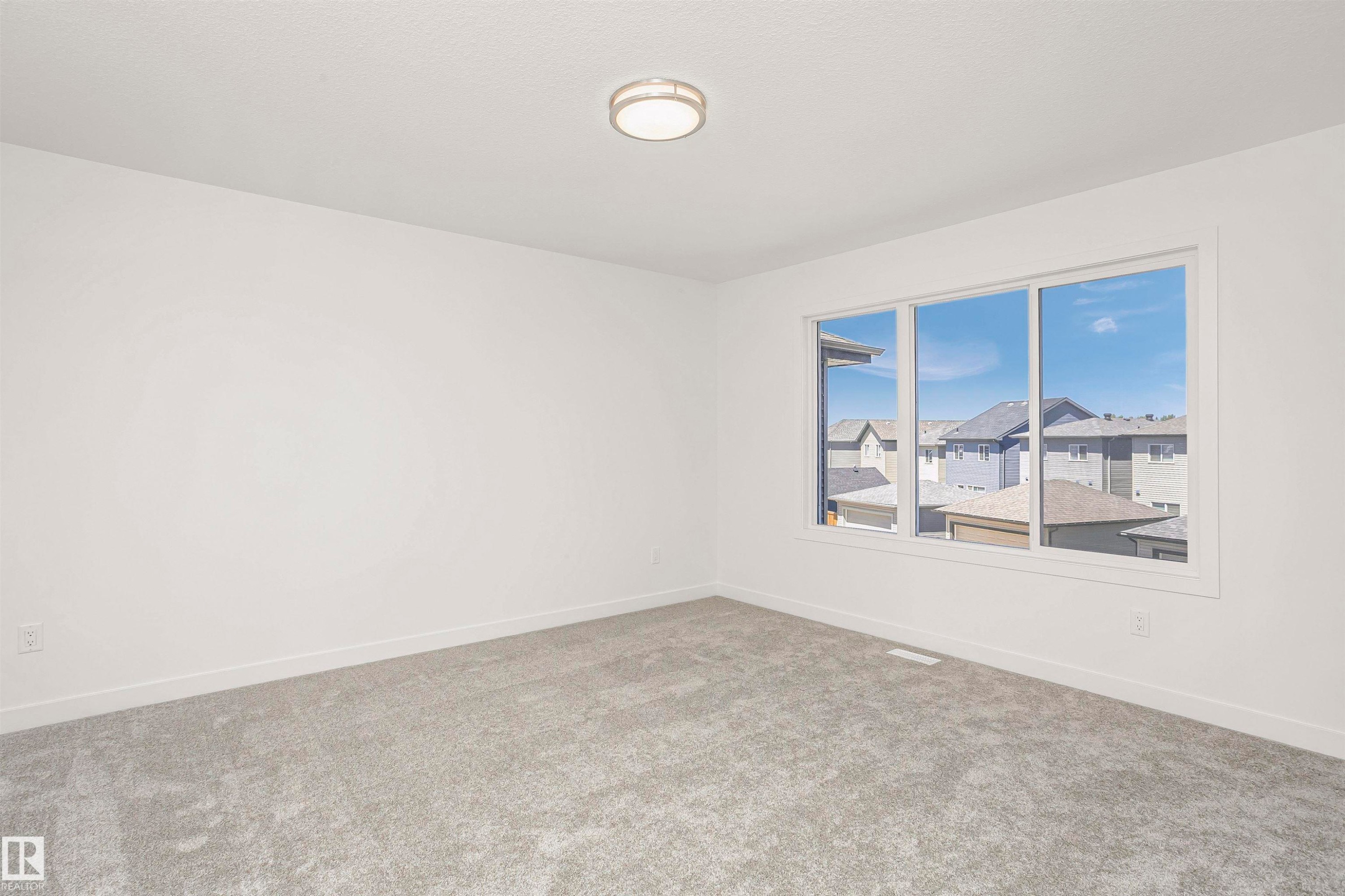 Bright room with neutral gray carpeting and white walls - 9552 Carson Bend Bend, Edmonton, AB - Indoor Photo Showing Other Room