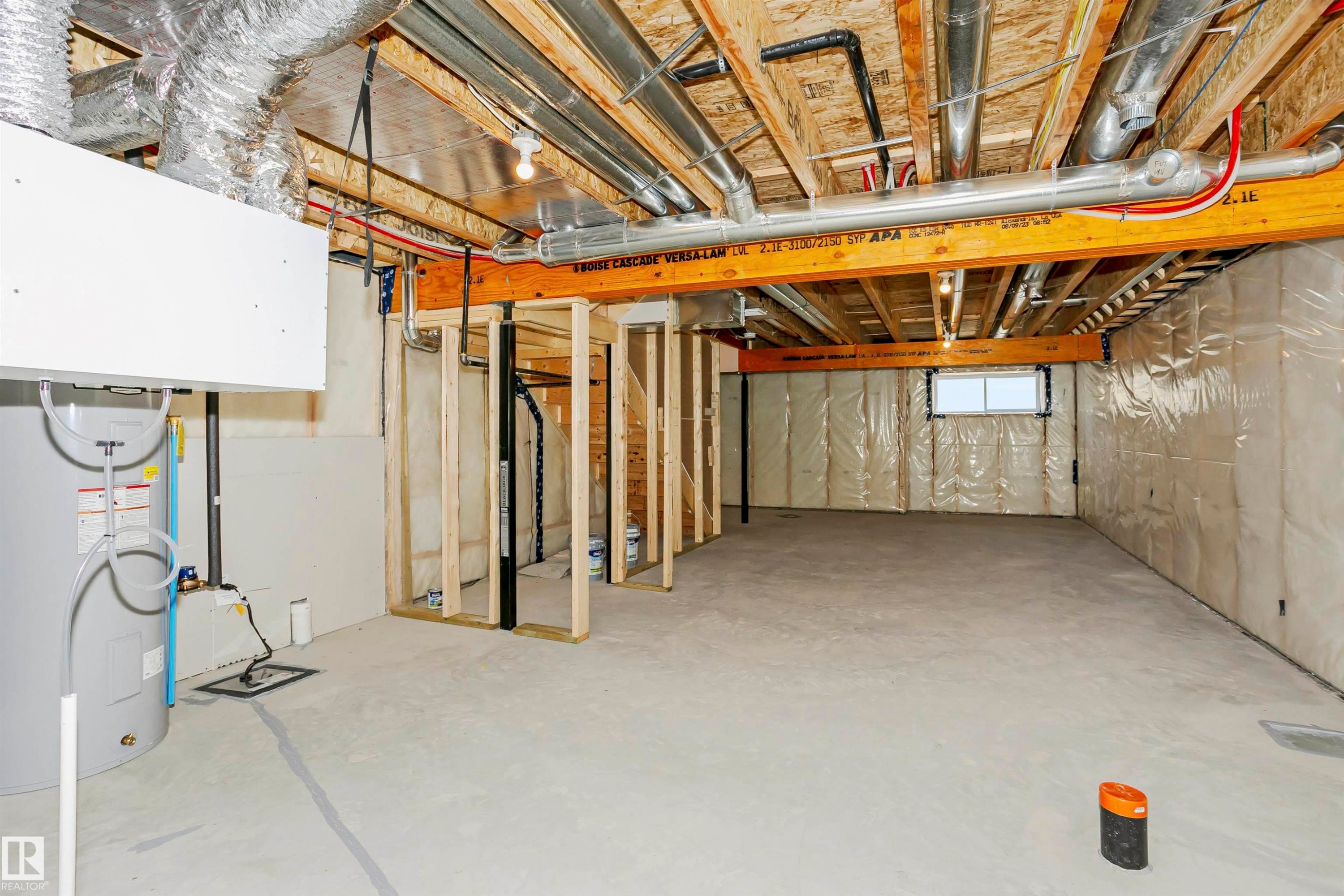 Unfinished lower level featuring exposed ceiling joists, concrete flooring, and a water heater - 9552 Carson Bend Bend, Edmonton, AB - Indoor Photo Showing Basement