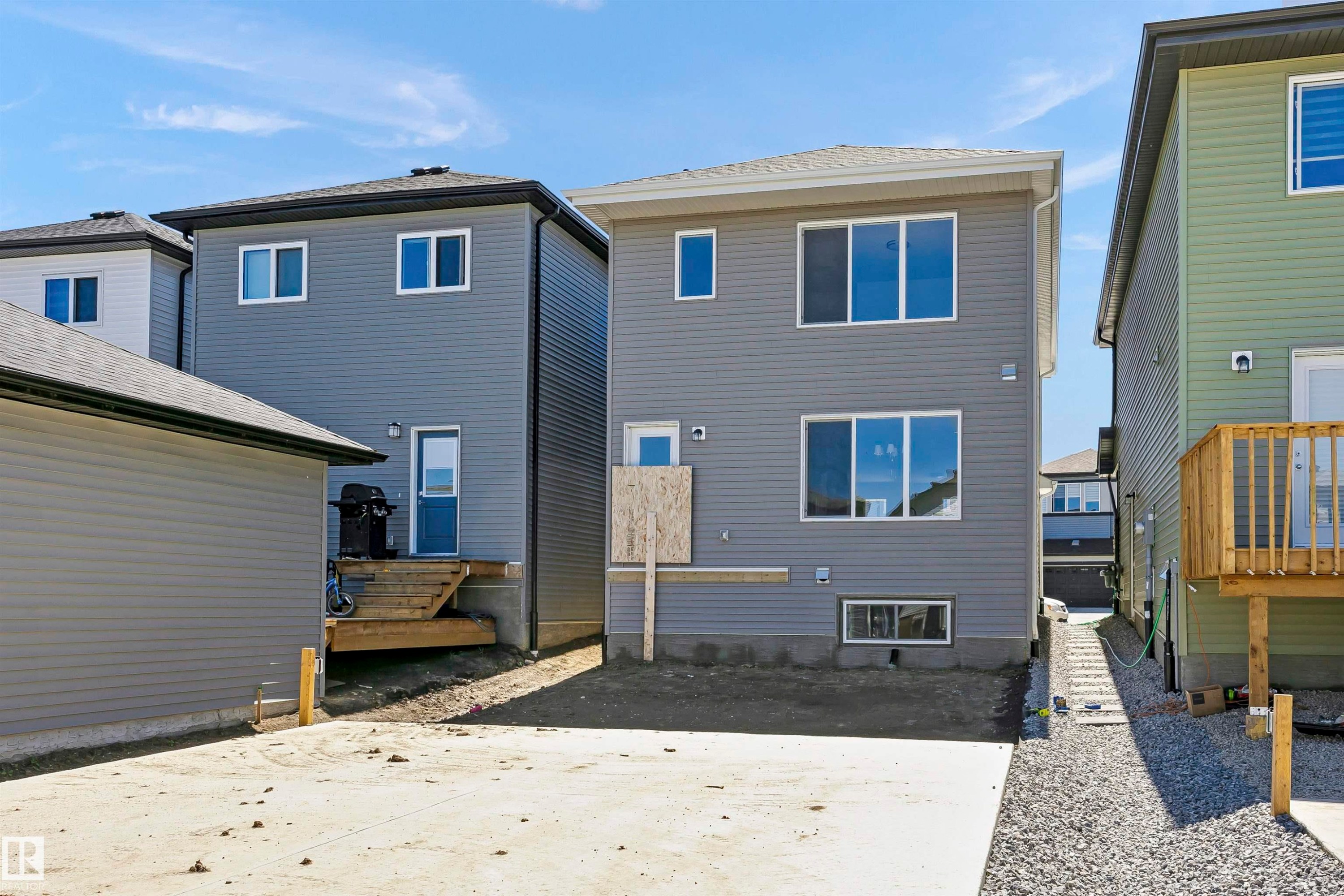 Rear exterior of a newly constructed residence featuring gray horizontal siding and a dark gray roof - 9552 Carson Bend Bend, Edmonton, AB - Outdoor With Exterior