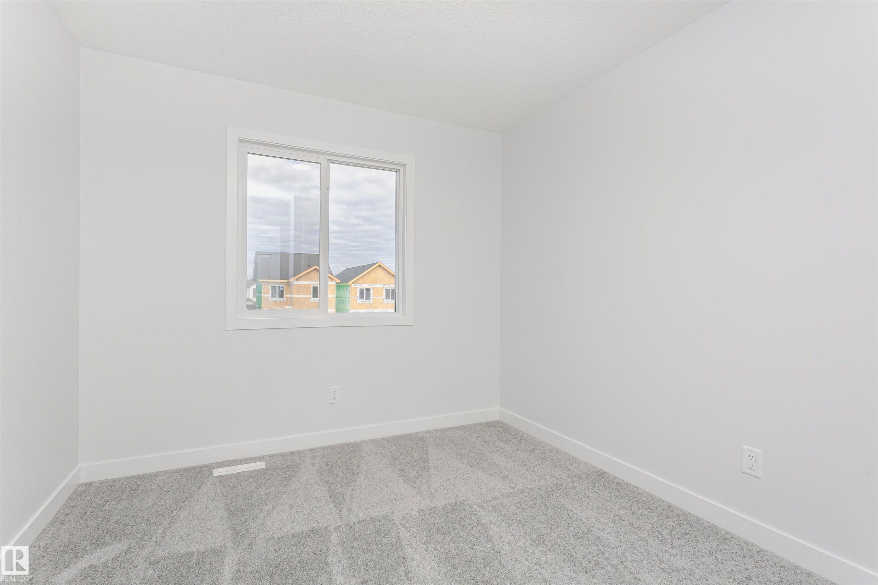 Room with light gray patterned carpet and white baseboards - 9564 Carson Bend Bend, Edmonton, AB - Indoor Photo Showing Other Room