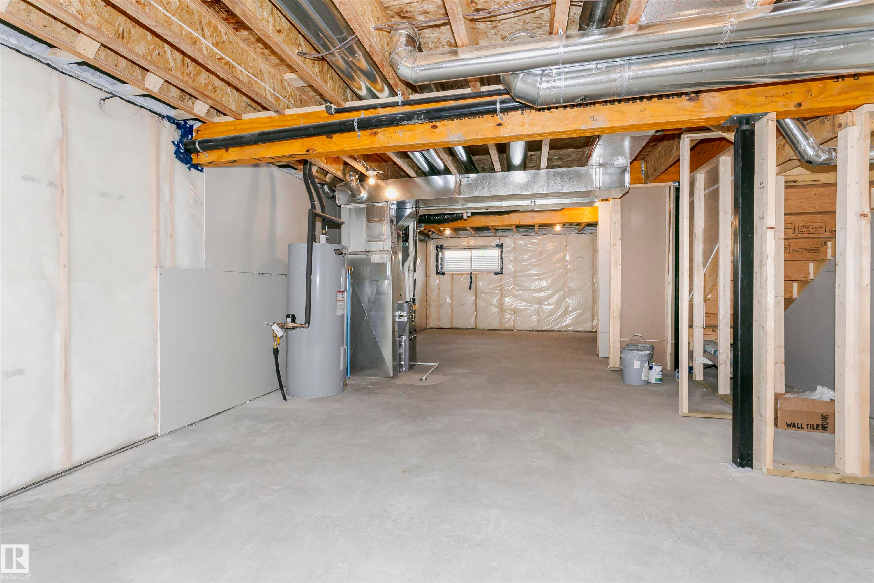 Unfinished lower level featuring exposed wood joists, structural wood beams, concrete flooring, and visible ductwork - 9564 Carson Bend Bend, Edmonton, AB - Indoor Photo Showing Basement
