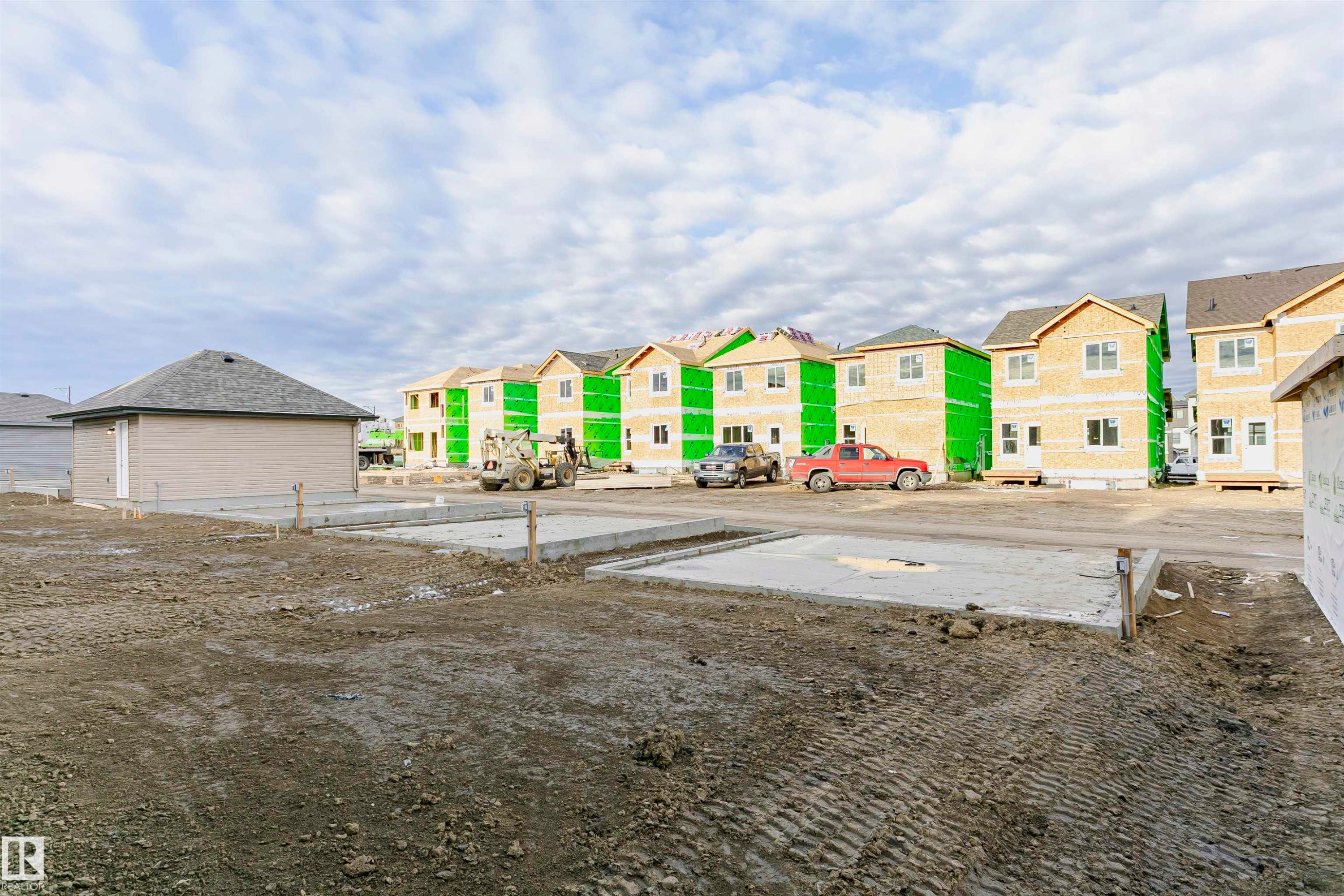 New construction foundations in place, with multiple framed homes in various stages of completion - 9564 Carson Bend Bend, Edmonton, AB - Outdoor