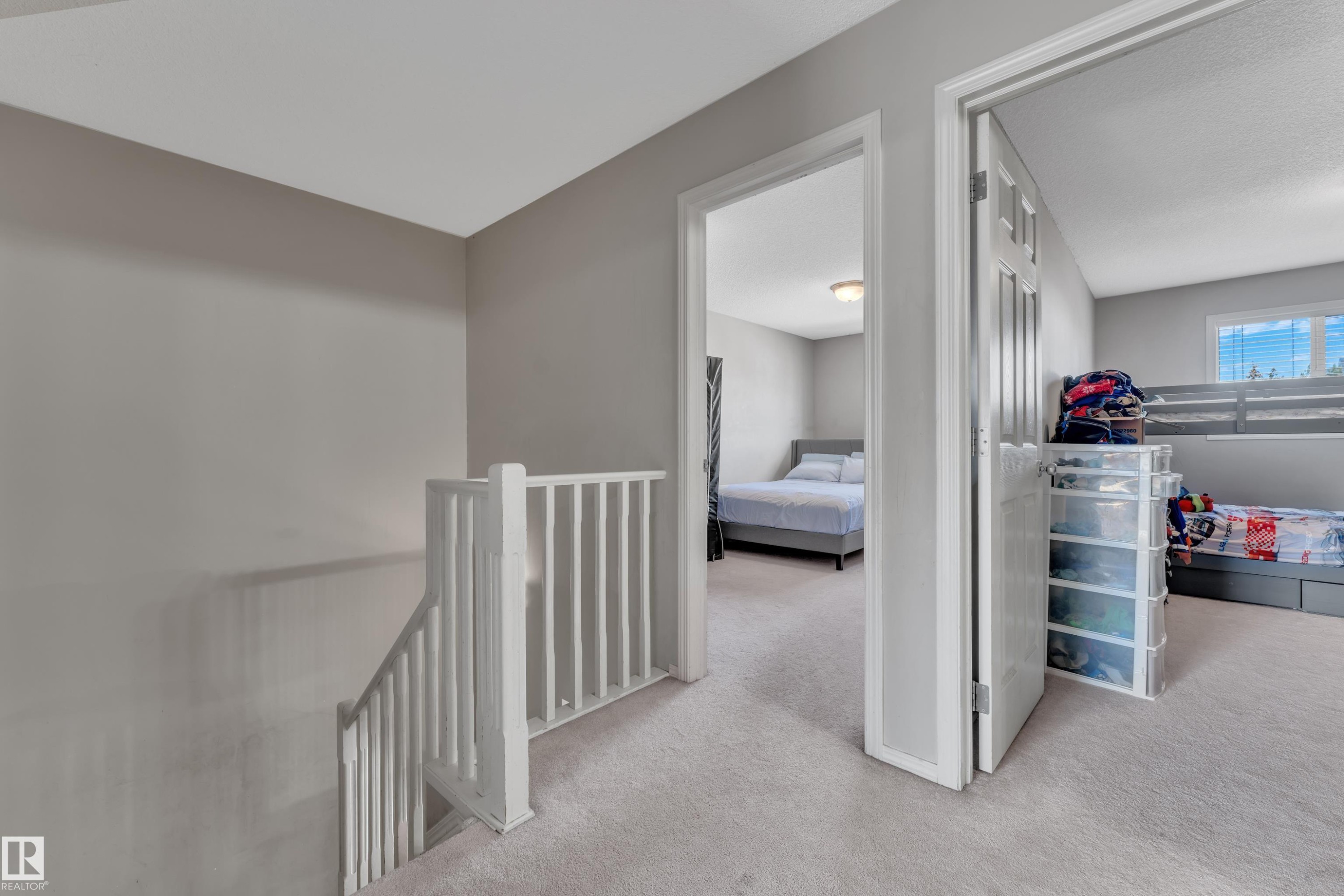 Upper-level hallway with light gray walls and plush carpet flooring - #64 4350 23 St Nw, Edmonton, AB - Indoor