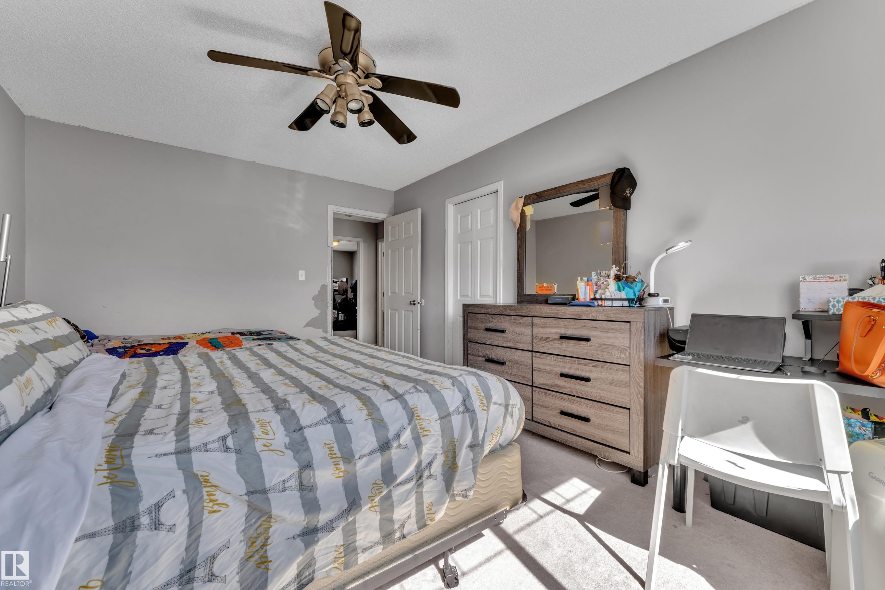 Bedroom featuring light gray wall paint, a ceiling fan with integrated lighting, and neutral-toned carpeting - #64 4350 23 St Nw, Edmonton, AB - Indoor Photo Showing Bedroom