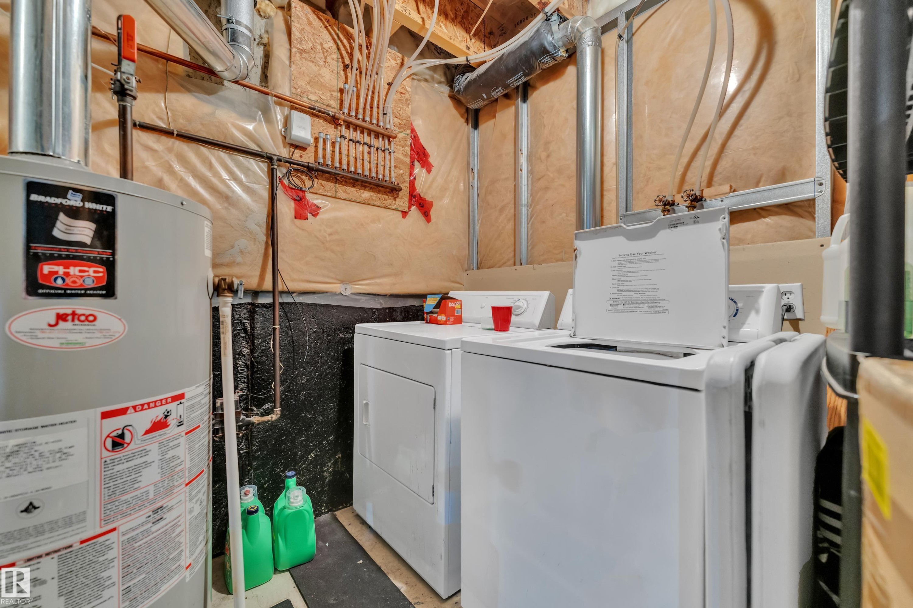 Utility area featuring a water heater and laundry appliances - #64 4350 23 St Nw, Edmonton, AB - Indoor Photo Showing Laundry Room