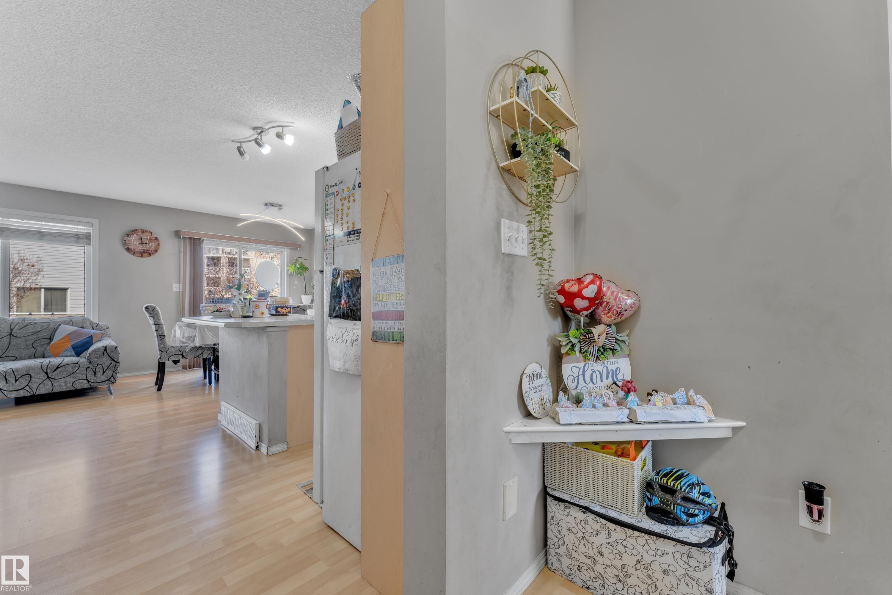 Open-concept living space featuring wood-finish flooring, recessed lighting, and ample natural light from multiple windows - #64 4350 23 St Nw, Edmonton, AB - Indoor
