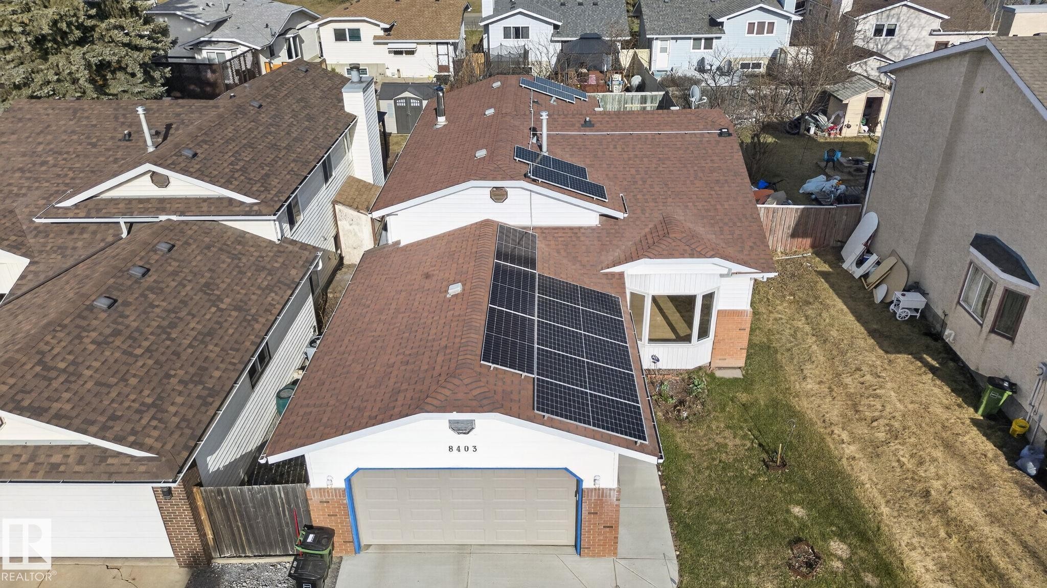 Property featuring a brown shingle roof with multiple solar panel installations - 8403 190 Street, Edmonton, AB - Outdoor With Exterior