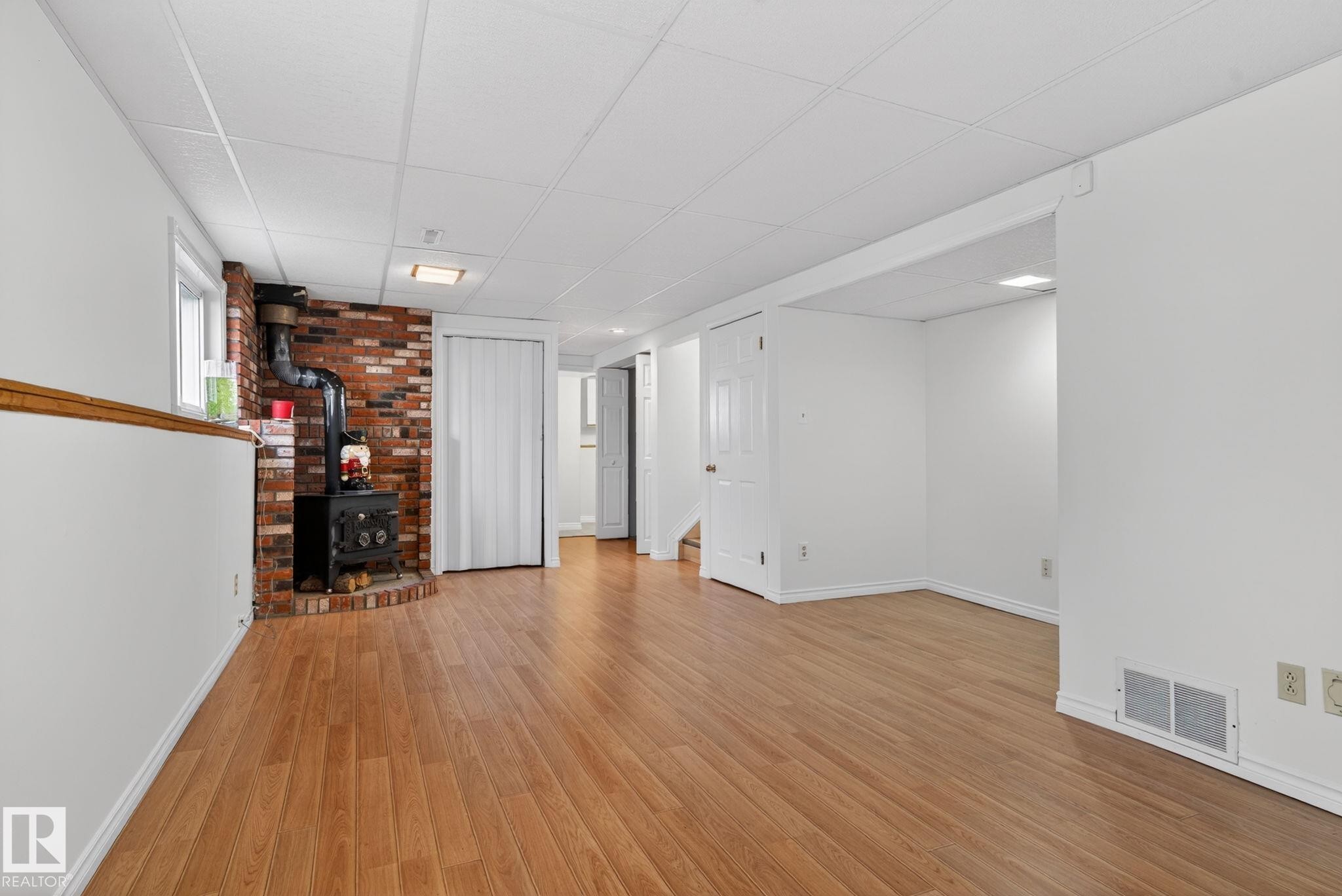 Spacious finished lower level featuring wood-finish flooring and white painted walls - 8403 190 Street, Edmonton, AB - Indoor Photo Showing Other Room